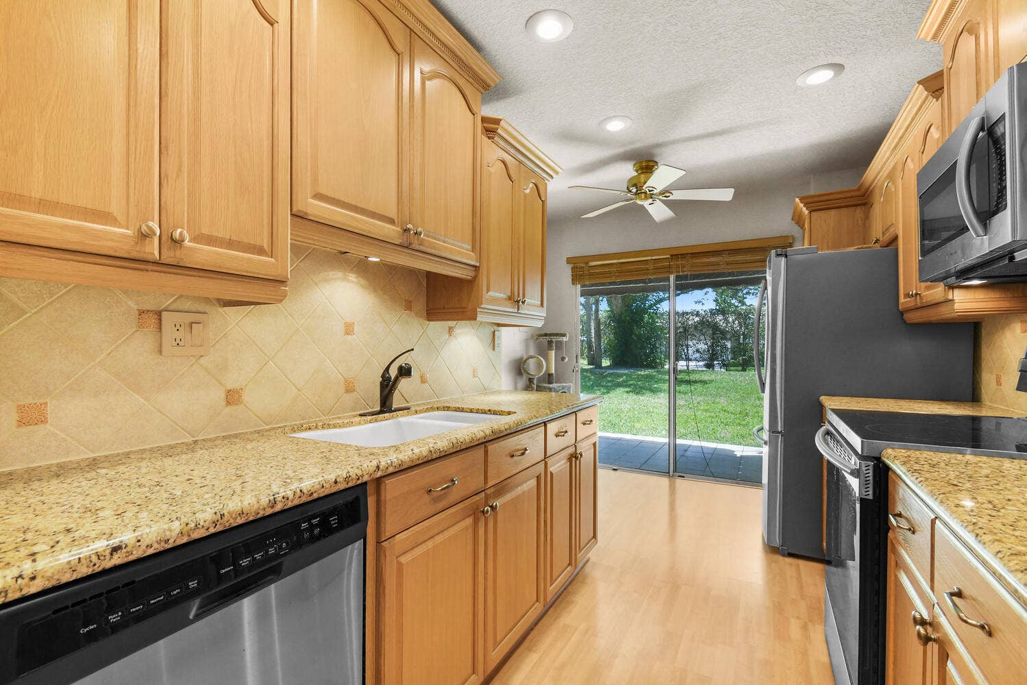 5266 Sapphire Valley, Boca Raton, FL 33486 Beautifully updated kitchen featuring granite countertops, abundant cabinetry, stainless steel appliances, recessed lighting, and direct access to the patio, creating a bright and functional space for everyday living.