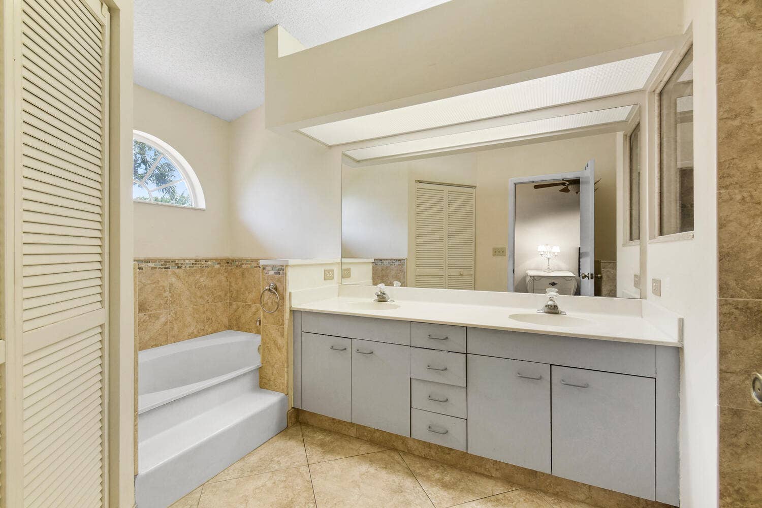 5266 Sapphire Valley, Boca Raton, FL 33486 Spacious ensuite bathroom featuring an oversized dual-sink vanity, abundant storage, a soaking tub, separate shower, and vaulted ceilings. Natural light and an open layout create a bright and relaxing retreat within the primary suite.