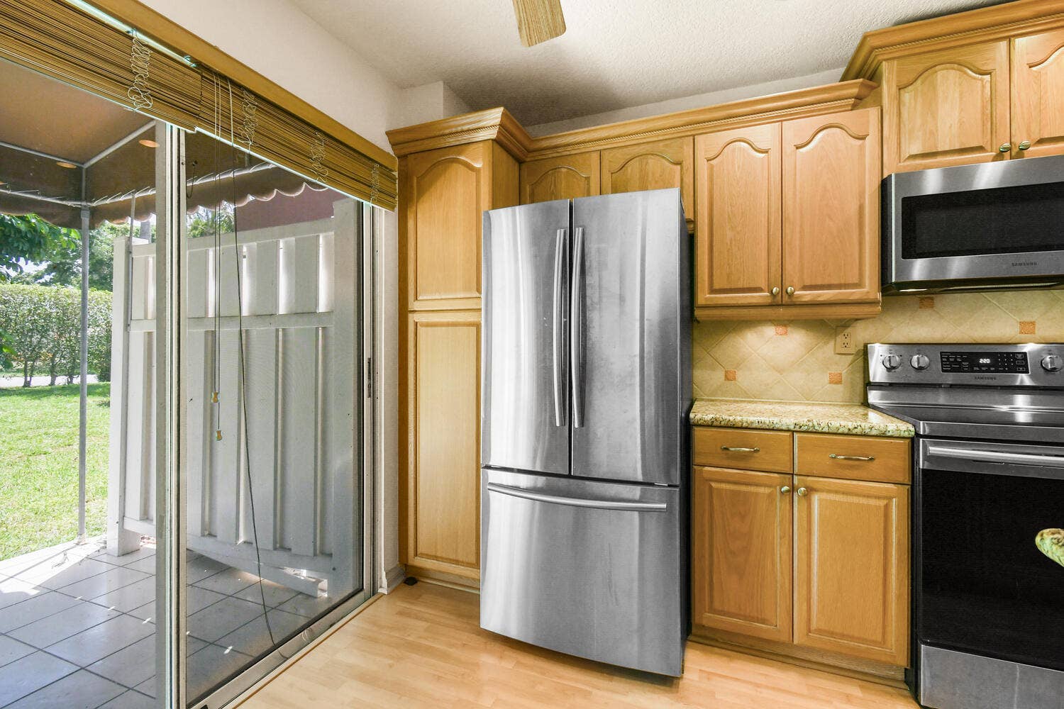 5266 Sapphire Valley, Boca Raton, FL 33486 Beautifully updated kitchen featuring granite countertops, abundant cabinetry, stainless steel appliances, recessed lighting, and direct access to the patio, creating a bright and functional space for everyday living.