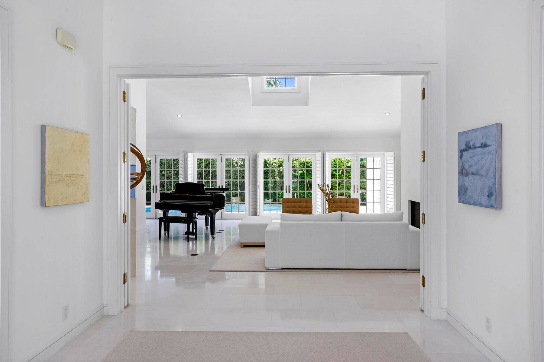 Foyer leading to living room with a solid wall of glass.