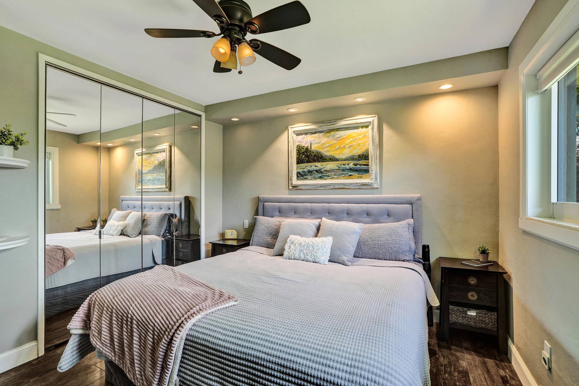 Private primary suite with custom built-in closet, luxury vinyl plank flooring, abundant natural light, and beautifully remodeled ensuite bath.