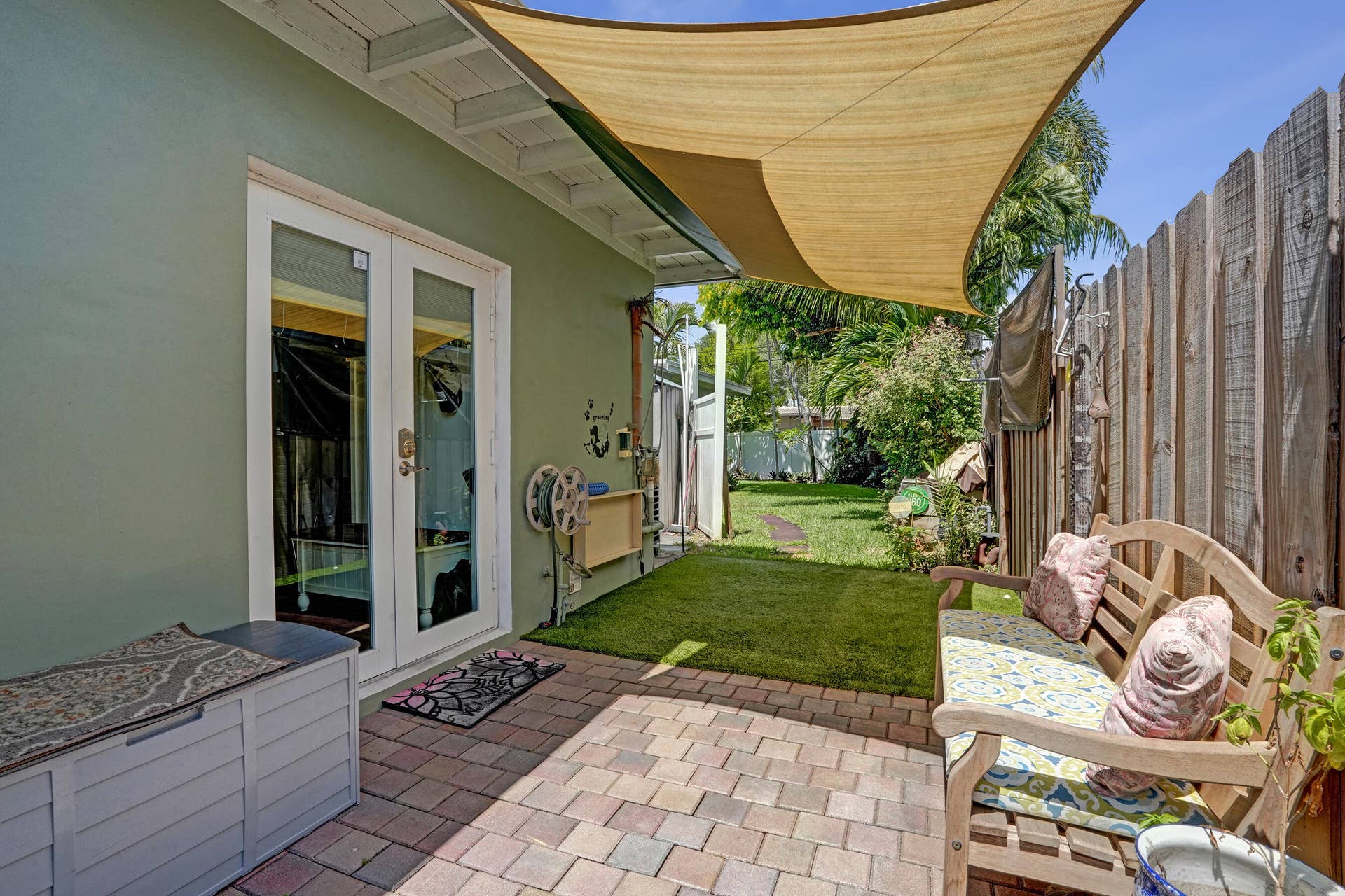 Private side yard featuring pet-friendly turf and a convenient outdoor wash stationperfect for rinsing off pets, kids, or after gardening.