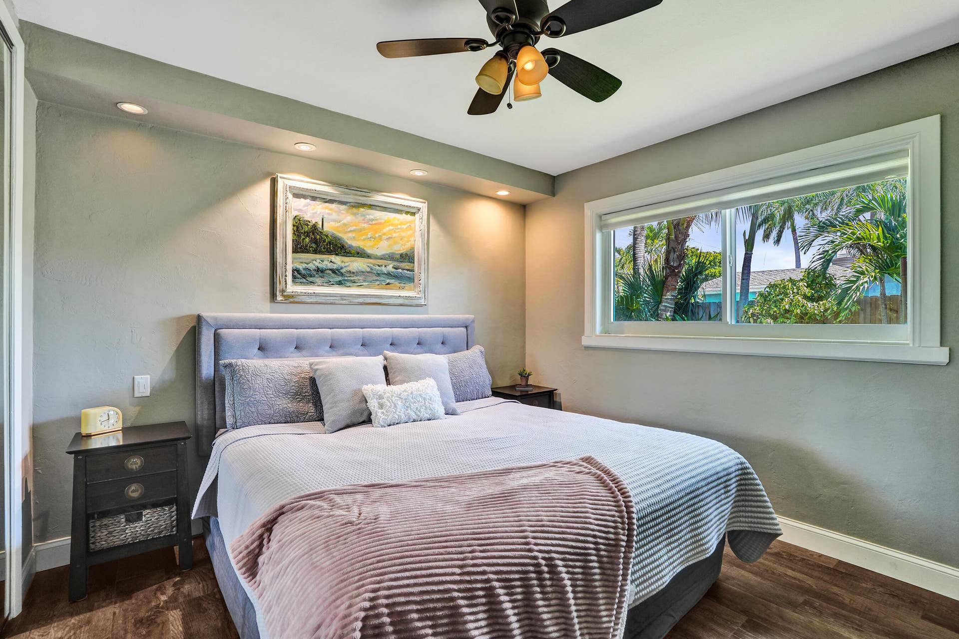 Private primary suite with custom built-in closet, luxury vinyl plank flooring, abundant natural light, and beautifully remodeled ensuite bath.