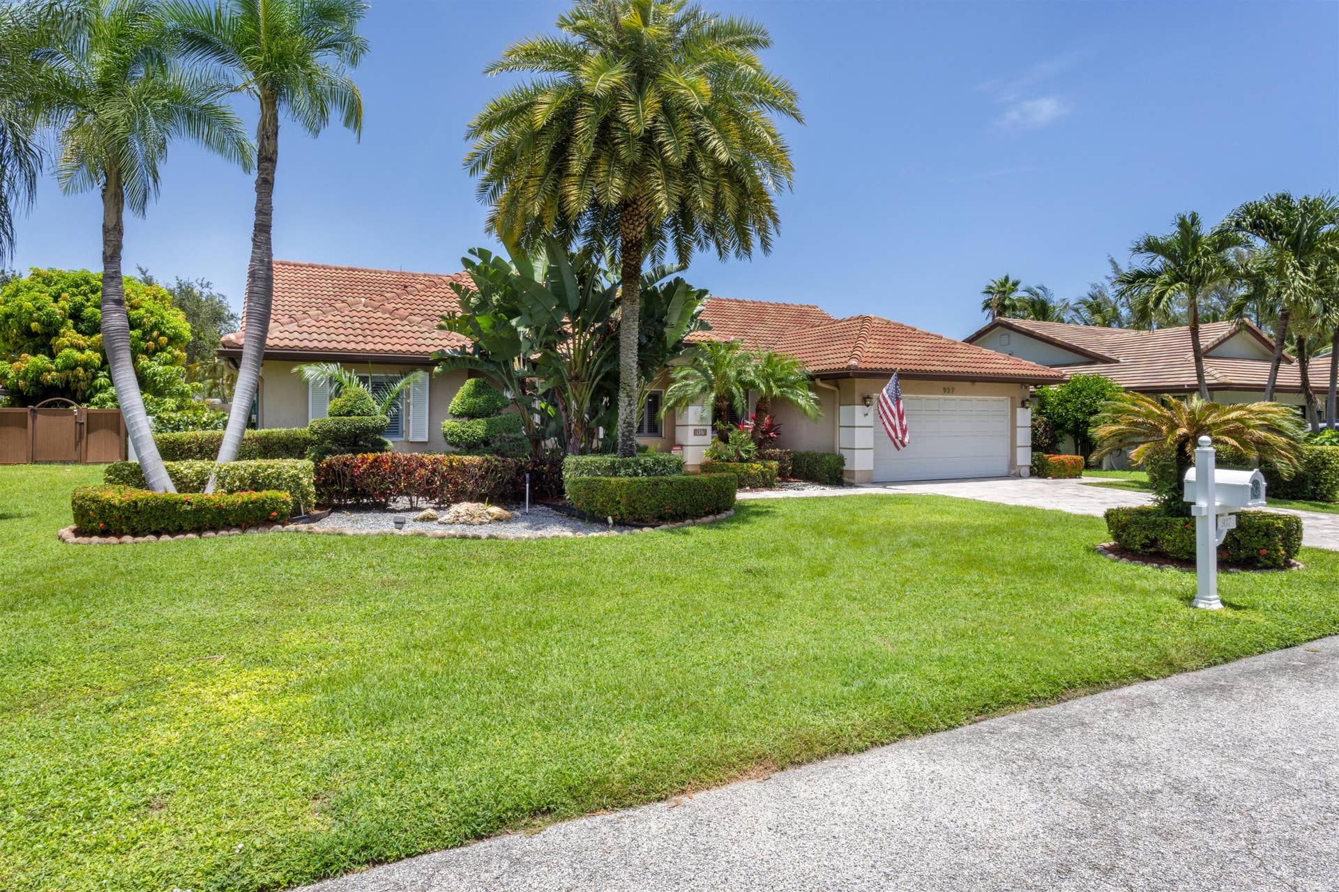 single-story with barrel tile roof and lush landscaping