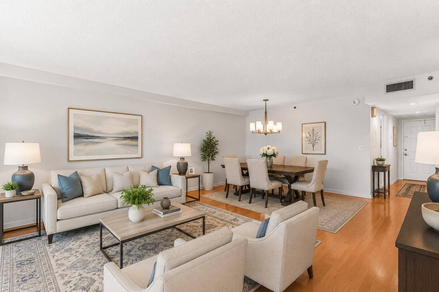 Virtually Staged expansive living and dining area showcases rich cherry hardwood flooring and an open, inviting layout that flows seamlessly to the screened balcony overlooking the golf course.