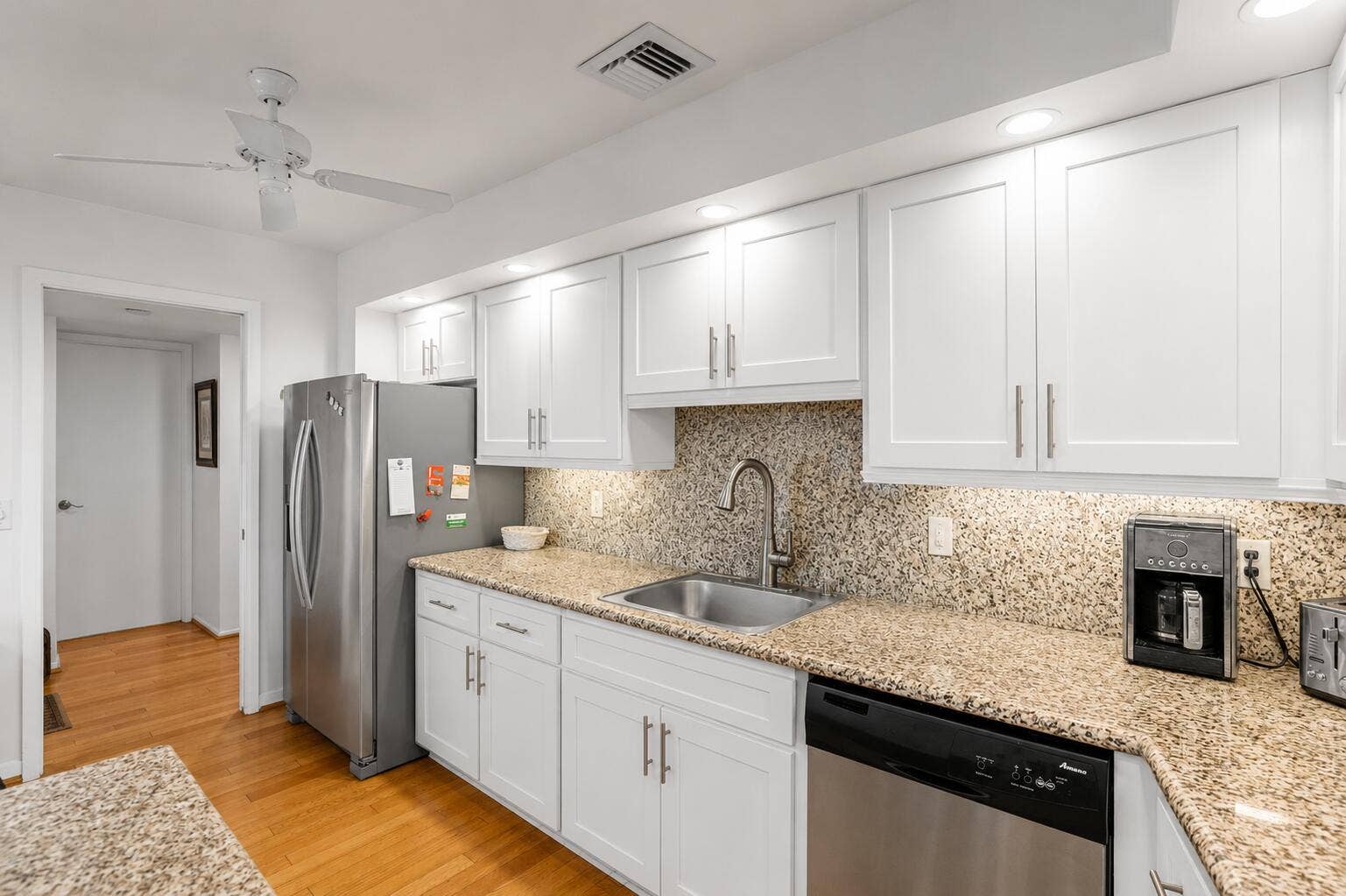 Virtually modified kitchen with white cabinets showing the potential with a simple refacing of the cabinets.