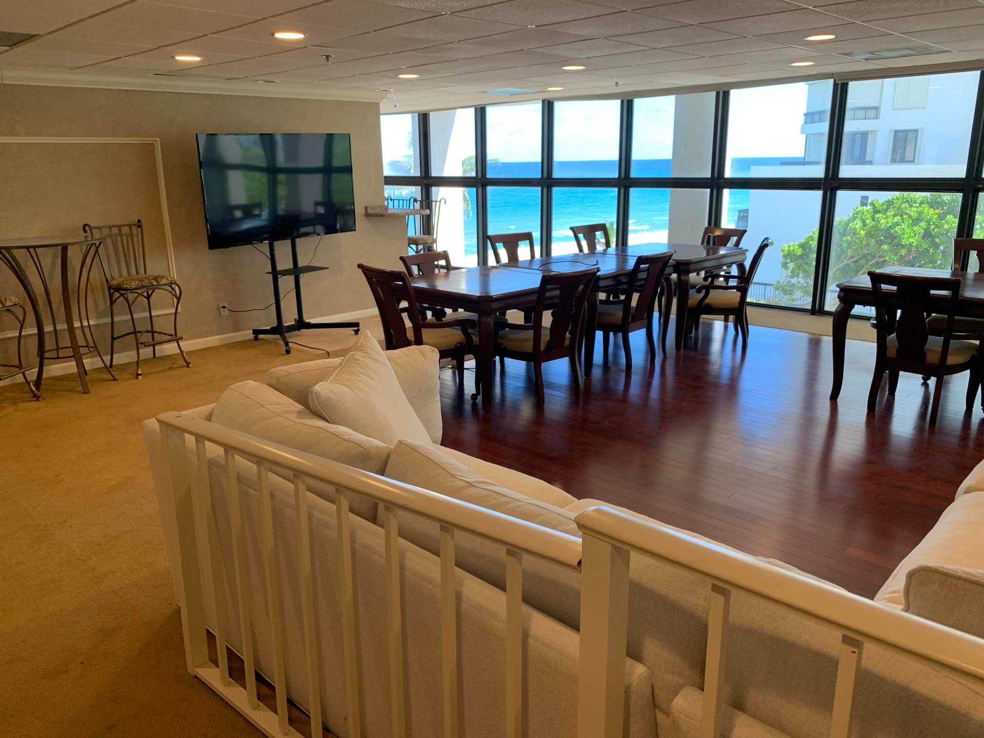 3115 S Ocean Boulevard, #1002, Highland Beach, FL 33487 Expansive common area featuring large windows with ocean scenery, wood-finish flooring, recessed lighting, and a neutral color palette