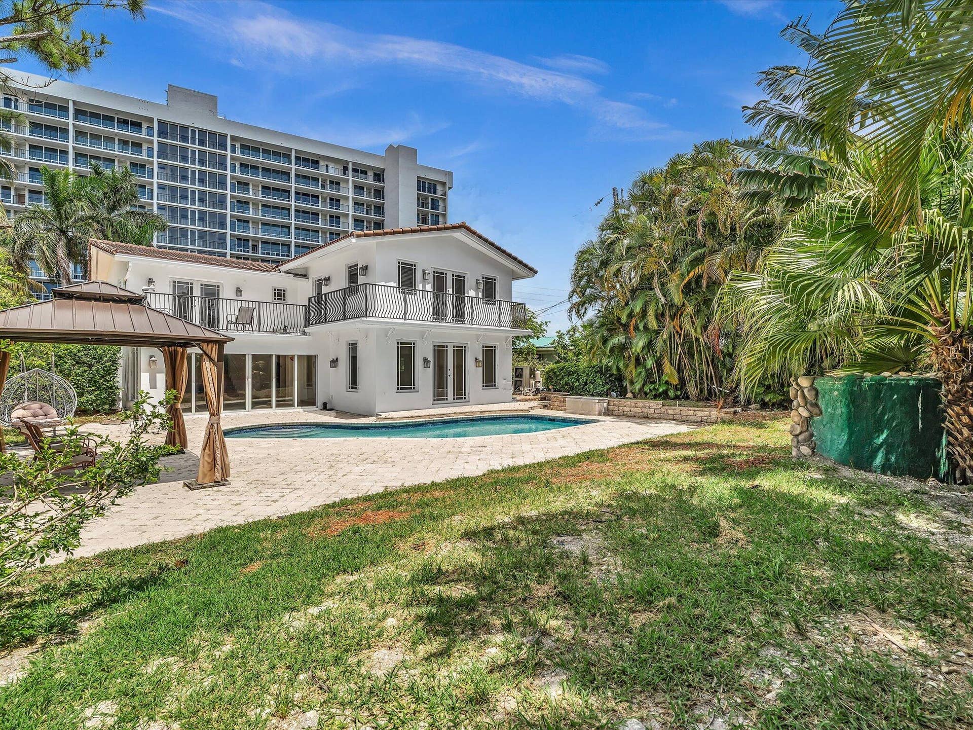 518 N Riverside Drive, Pompano Beach, FL 33062 White stucco exterior with a tiled roof, featuring multiple balconies with black wrought iron railings