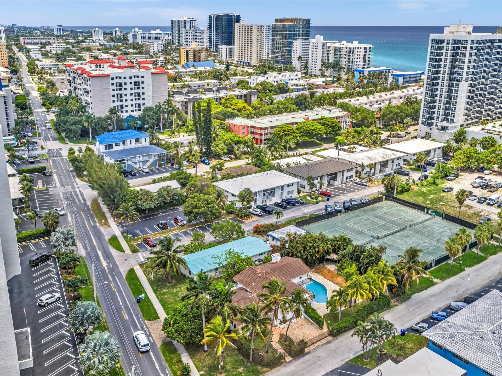 518 N Riverside Drive, Pompano Beach, FL 33062 Single-family residence featuring a private swimming pool, surrounded by mature palm trees