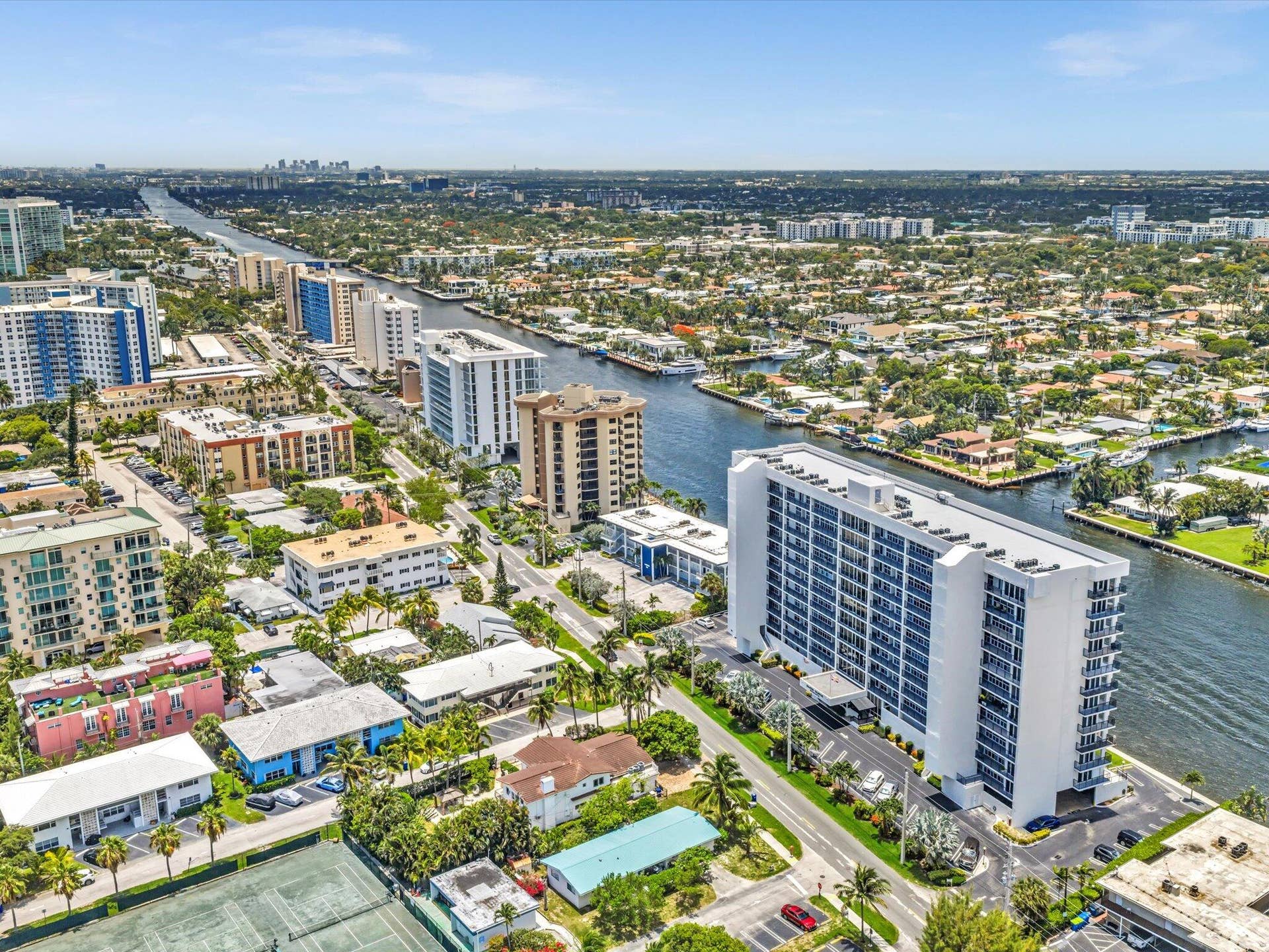 518 N Riverside Drive, Pompano Beach, FL 33062 High-rise residential building featuring multiple balconies, a surrounding paved parking area, and manicured landscaping