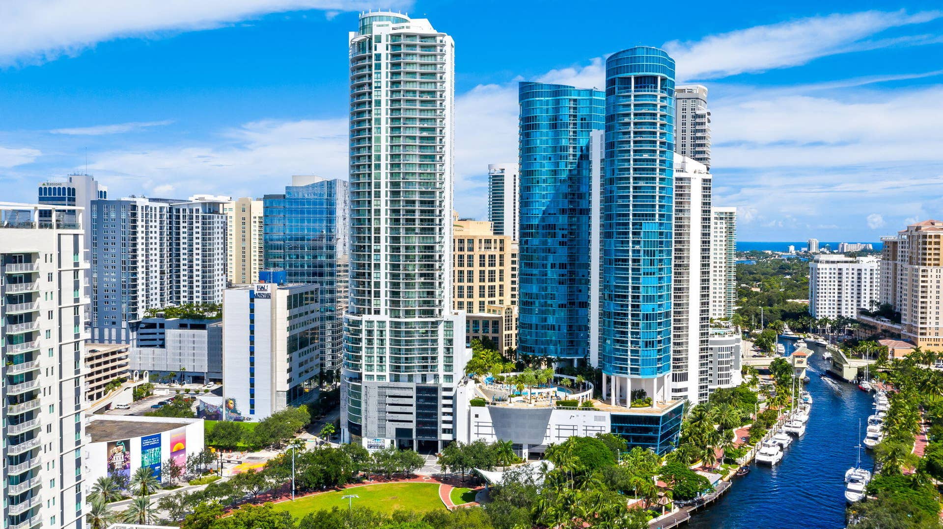 100 E Las Olas Boulevard, #3804, Fort Lauderdale, FL 33301 Skyline featuring multiple high-rise structures, a waterway with docked boats, abundant green spaces, and distant ocean views