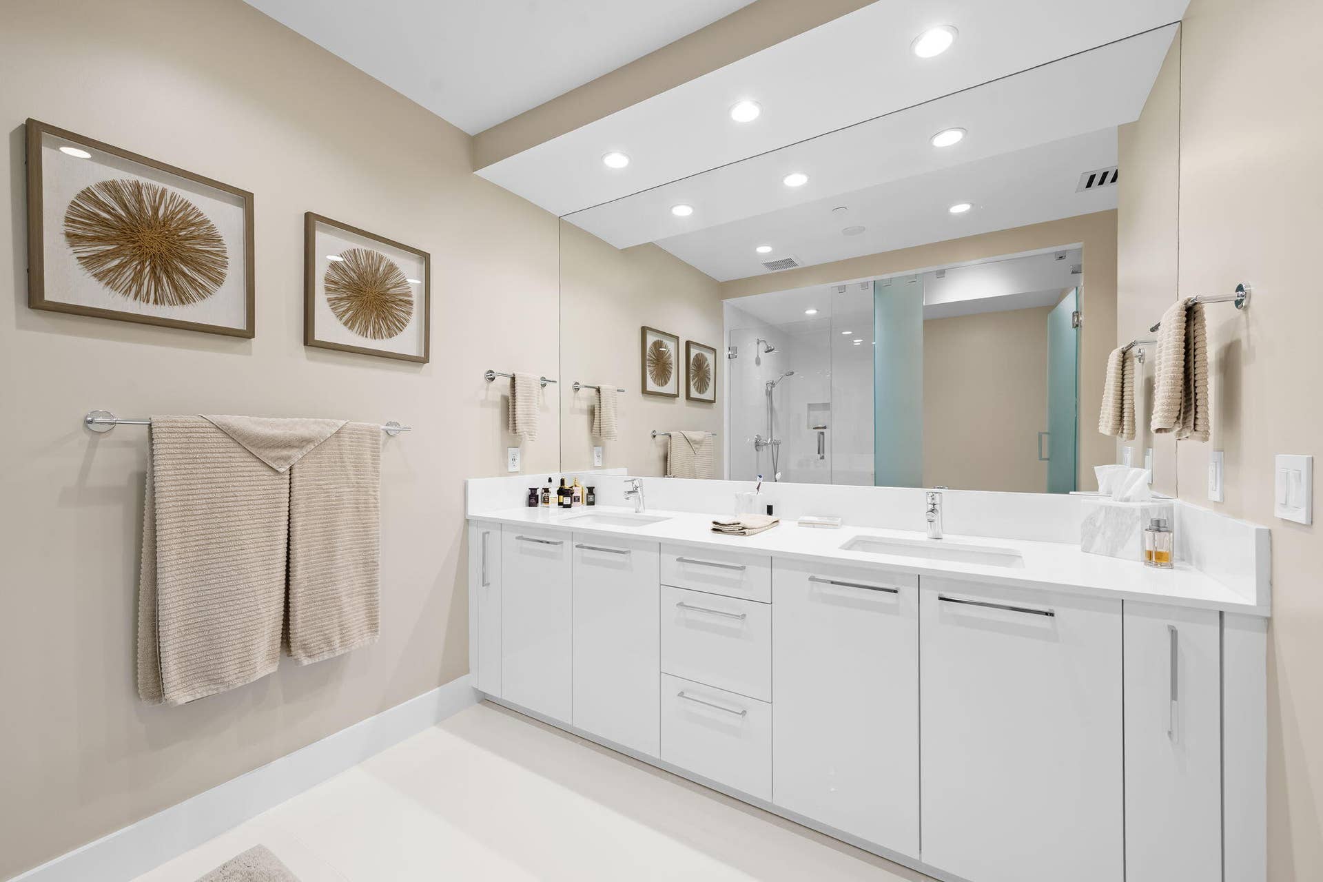 100 E Las Olas Boulevard, #3804, Fort Lauderdale, FL 33301 Dual vanity with white cabinetry, integrated sinks, chrome fixtures, and a spacious wall-mounted mirror