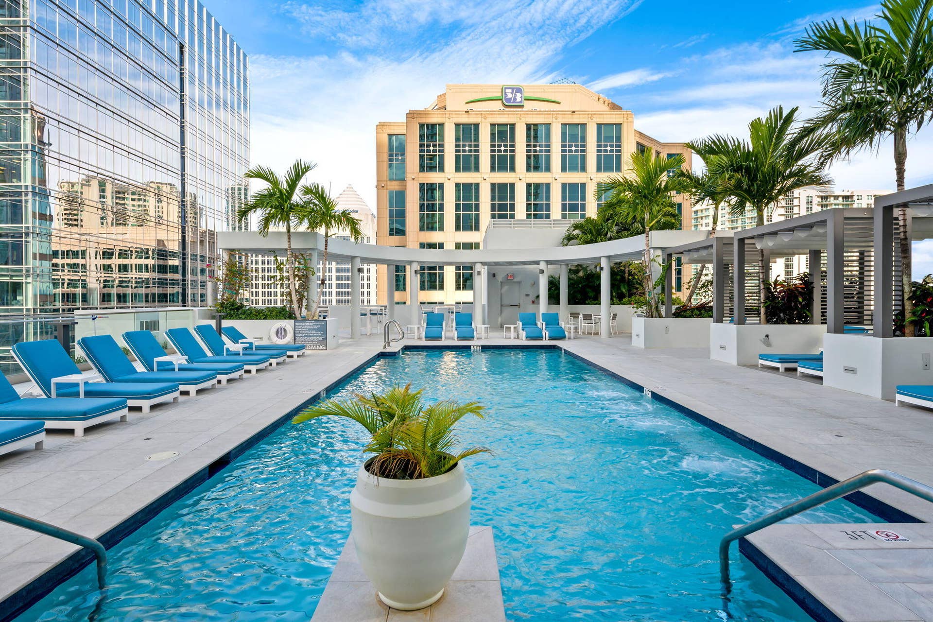 100 E Las Olas Boulevard, #3804, Fort Lauderdale, FL 33301 Rooftop amenity deck featuring a swimming pool, multiple lounge areas, poolside cabanas, and integrated planters with mature palm trees