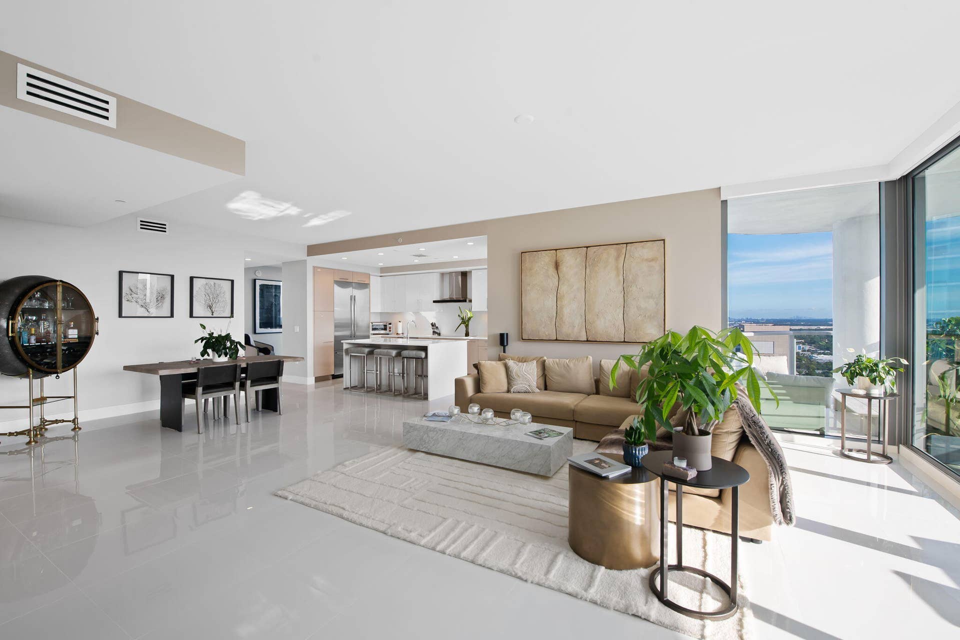 100 E Las Olas Boulevard, #3804, Fort Lauderdale, FL 33301 Spacious open-concept living area featuring light-toned flooring, a modern kitchen with an island, a dedicated dining space, and floor-to-ceiling windows