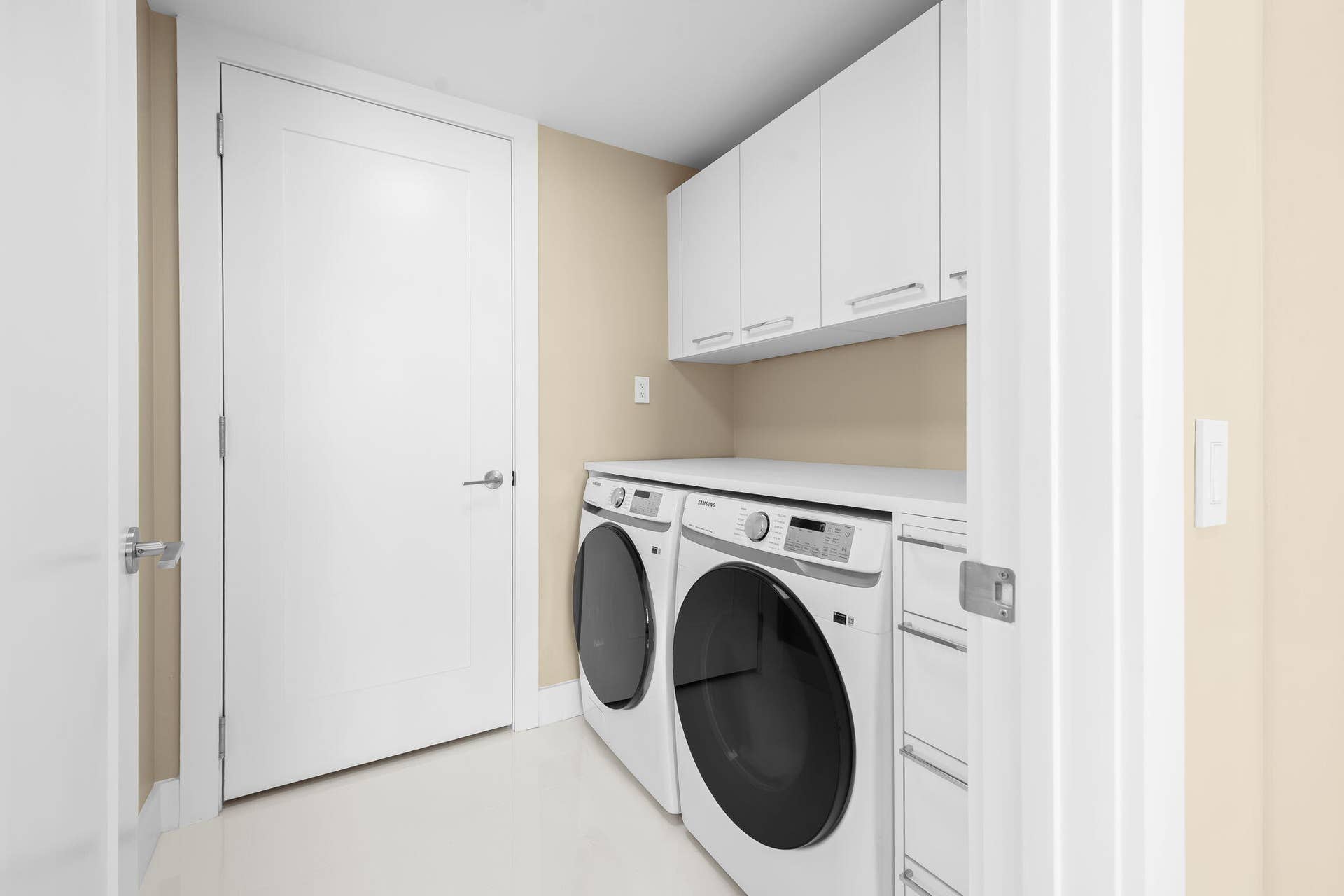 100 E Las Olas Boulevard, #3804, Fort Lauderdale, FL 33301 Dedicated laundry space featuring a side-by-side washer and dryer, white cabinetry, a white countertop, and light-toned wall paint