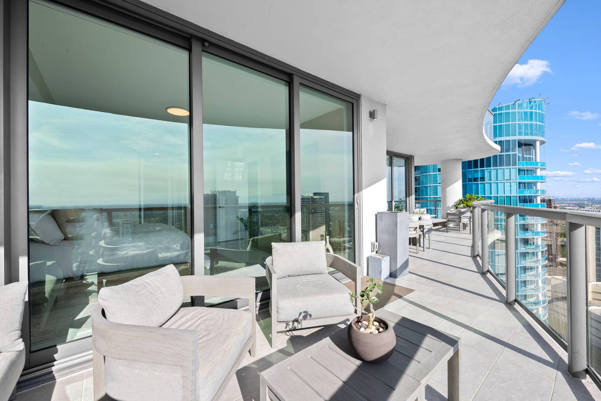 100 E Las Olas Boulevard, #3804, Fort Lauderdale, FL 33301 Expansive private balcony featuring glass railings, a curved ceiling, and light-tone tile flooring
