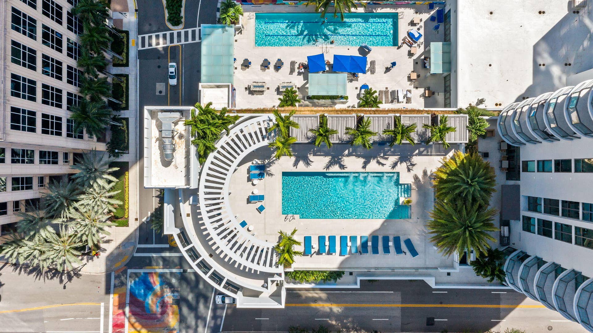 100 E Las Olas Boulevard, #3804, Fort Lauderdale, FL 33301 Dual swimming pools surrounded by lounge areas, palm trees, and modern architecture