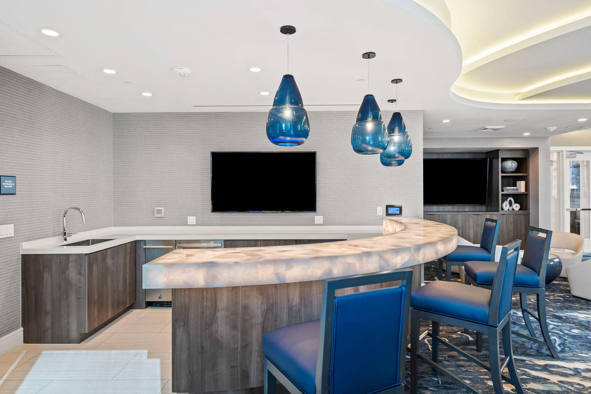 100 E Las Olas Boulevard, #3804, Fort Lauderdale, FL 33301 Curved bar with an illuminated countertop, integrated sink, and modern cabinetry