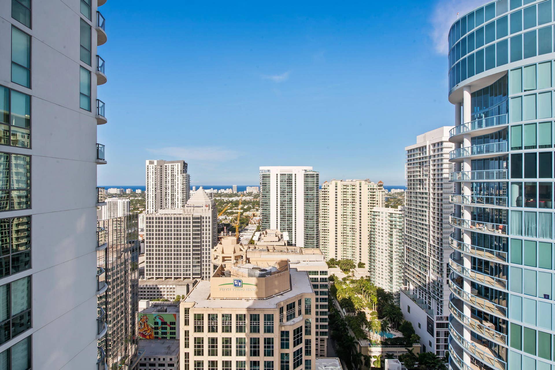 100 E Las Olas Boulevard, #3804, Fort Lauderdale, FL 33301 Expansive urban panorama featuring a mix of high-rise structures, a distant water body, and a blue sky