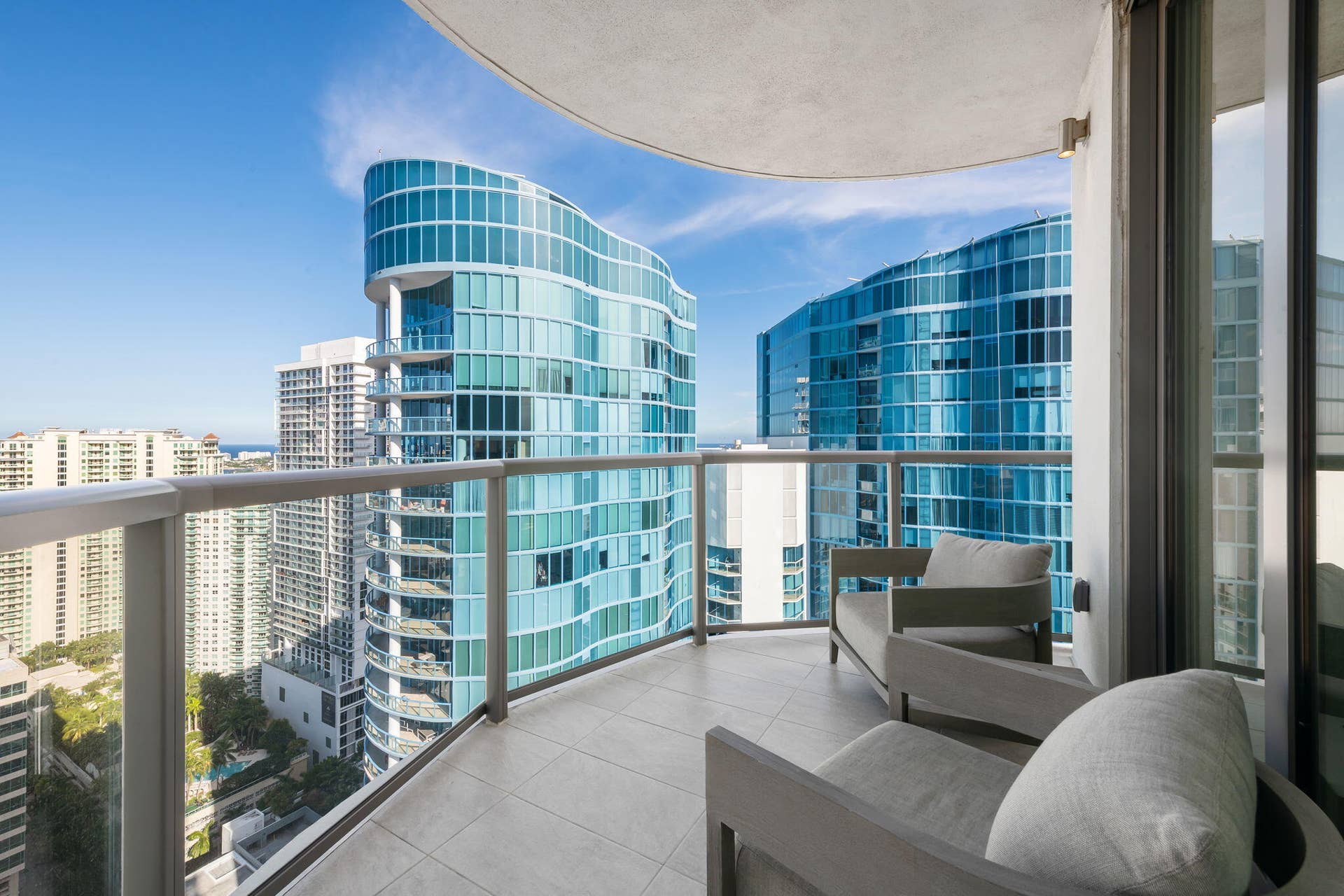 100 E Las Olas Boulevard, #3804, Fort Lauderdale, FL 33301 Curved balcony featuring tile flooring and glass railings with metal accents
