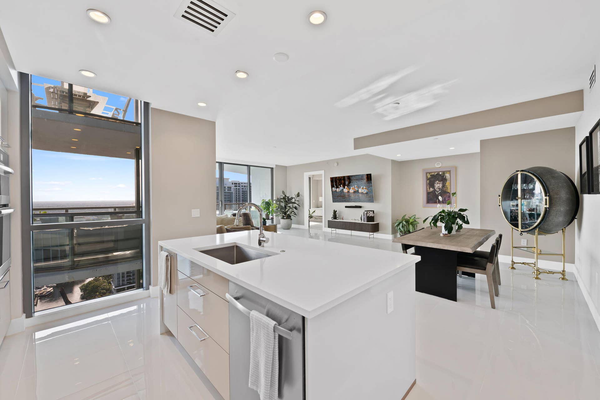 100 E Las Olas Boulevard, #3804, Fort Lauderdale, FL 33301 Modern kitchen island with an integrated sink, white countertop, and contemporary cabinetry
