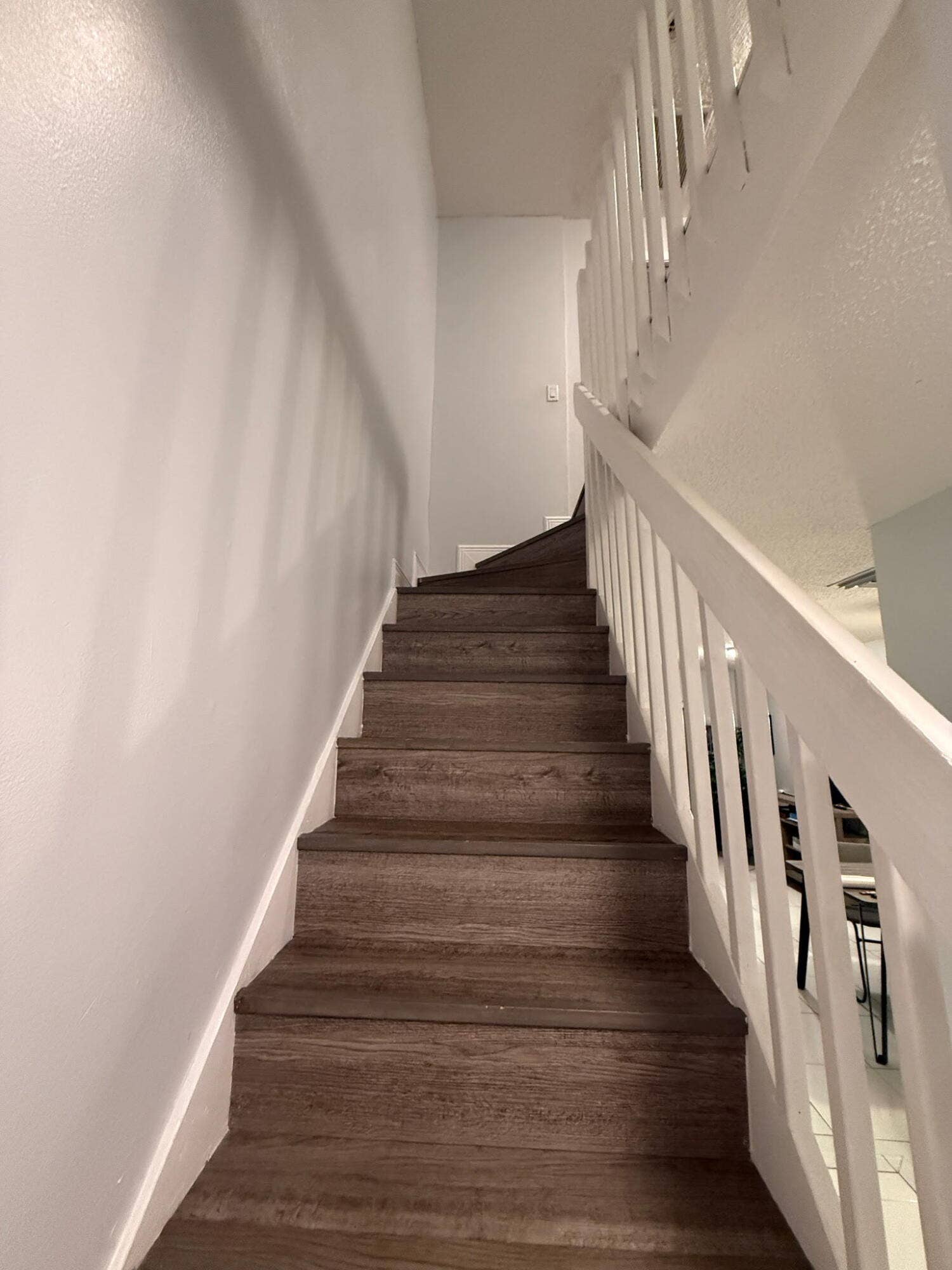 4121 NE 21st Terrace, #3, Lighthouse Point, FL 33064 Staircase featuring wood-finish treads and risers with white painted handrails and balusters