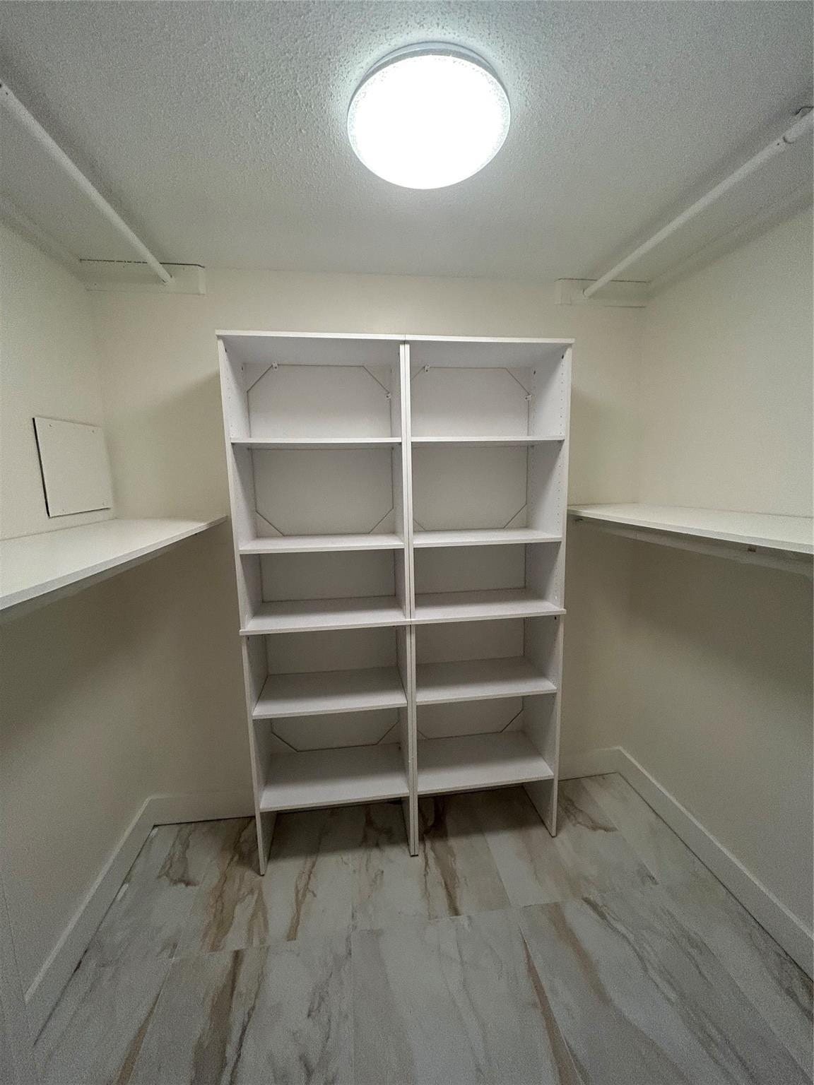 550 Bayshore Drive, #102, Fort Lauderdale, FL 33304 Walk in closet has crystal light fixture with remote control or wall switch, four hanging rods, two closet length size shelves, ten smaller shelves. Ceramic tile flooring,new baseboard and paint