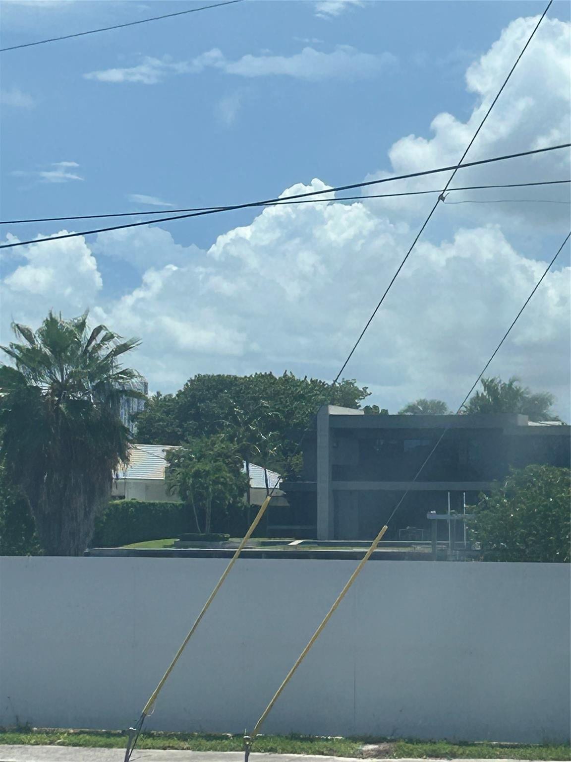 550 Bayshore Drive, #102, Fort Lauderdale, FL 33304 from windows are intracoastal waterway homes with greenery trees. A fence now stands infront of intracoastal view of water and boats going by can be seen above