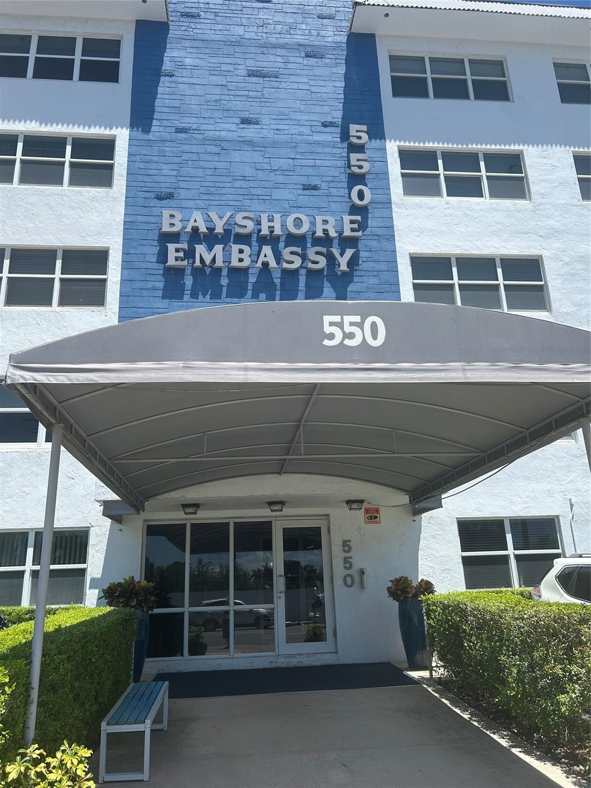 550 Bayshore Drive, #102, Fort Lauderdale, FL 33304 building entrance has canopy on walkway to front door. Landscape surrounds the sides and parking is assigned. Guest spaces are marked in yellow.
