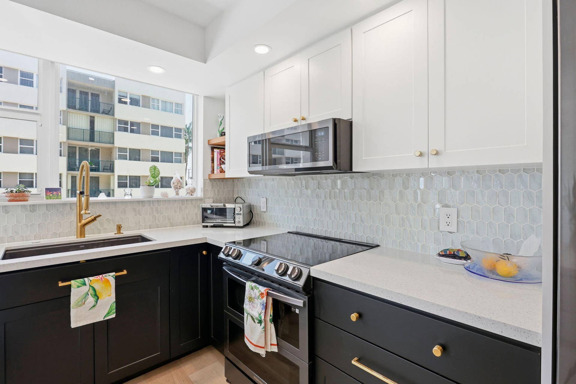 1239 Hillsboro Mile, #302, Hillsboro Beach, FL 33062 Modern kitchen with two-tone cabinetry, light-toned countertops, and a full-height geometric tile backsplash
