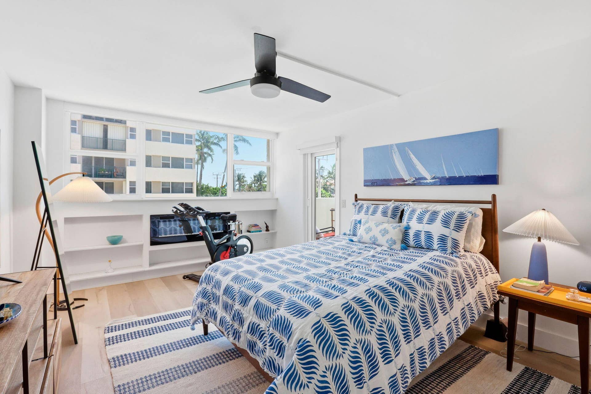 1239 Hillsboro Mile, #302, Hillsboro Beach, FL 33062 Bright bedroom featuring light wood look flooring, a contemporary ceiling fan, and a built-in shelving unit with a fireplace