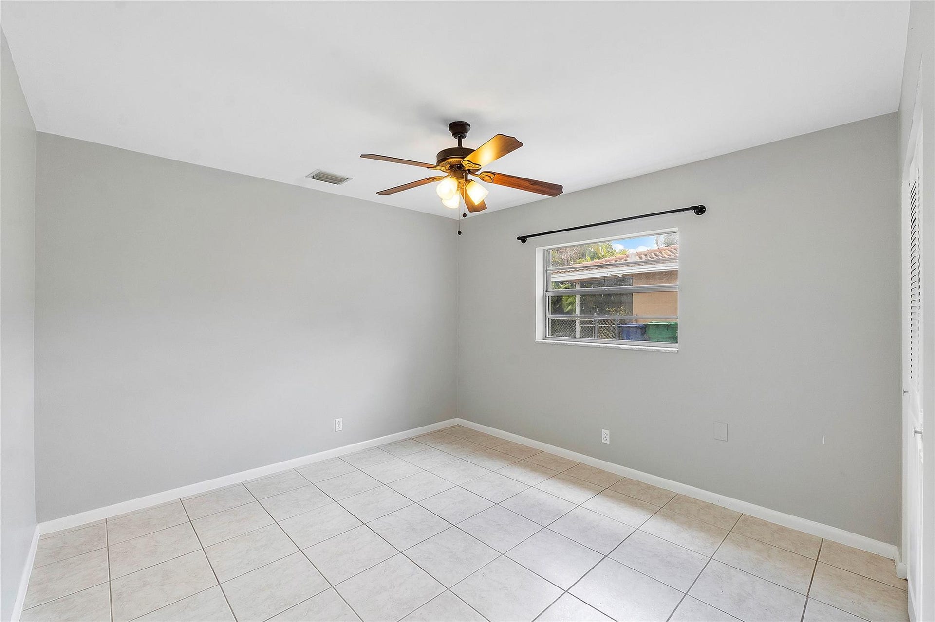 3843 NW 81st Terrace, Coral Springs, Coral Springs, FL 33065 Neutral-toned interior room featuring tile flooring, a window with exterior views, and a ceiling fan