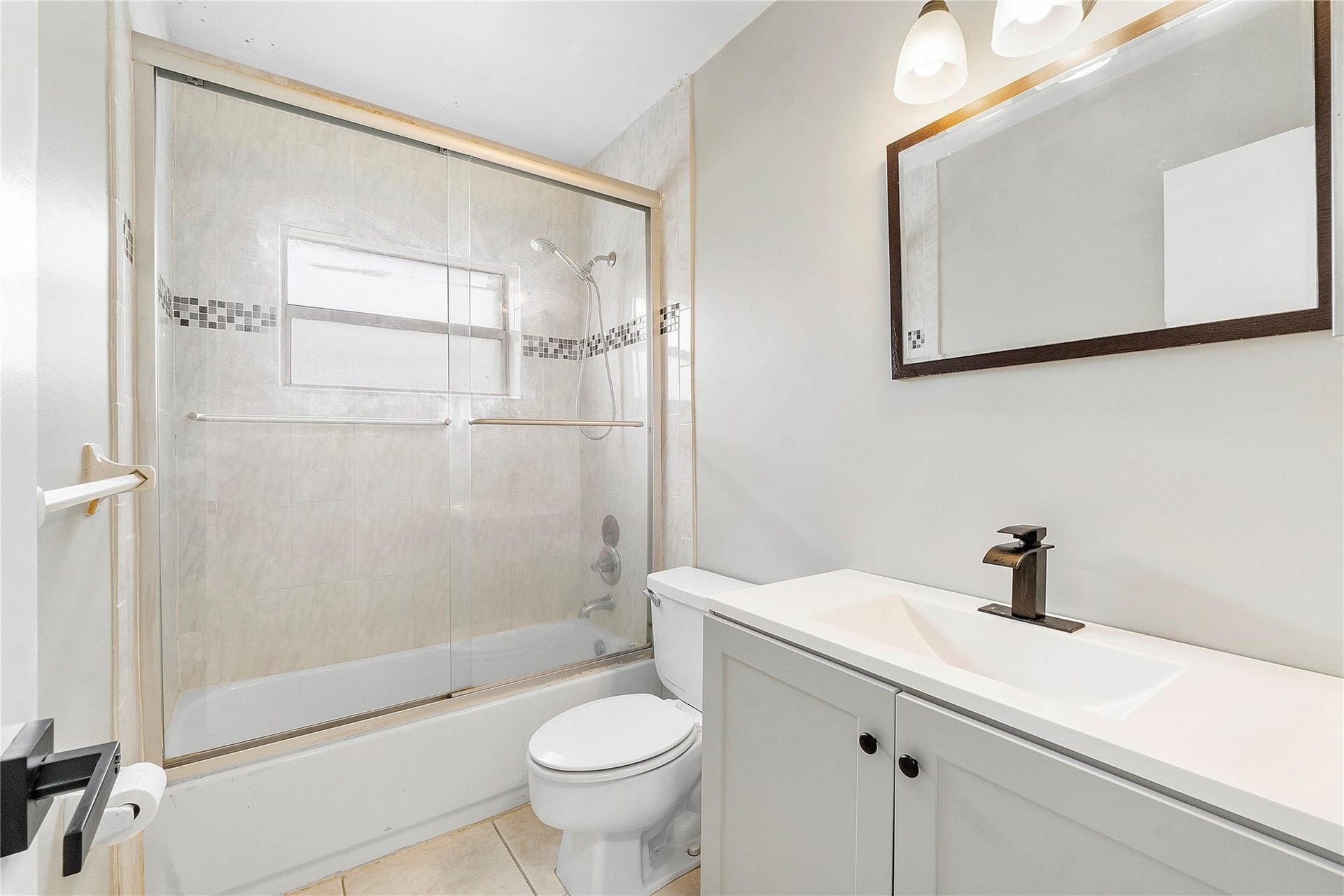 3843 NW 81st Terrace, Coral Springs, Coral Springs, FL 33065 Bathroom featuring a white vanity with integrated sink, bronze faucet, and framed mirror