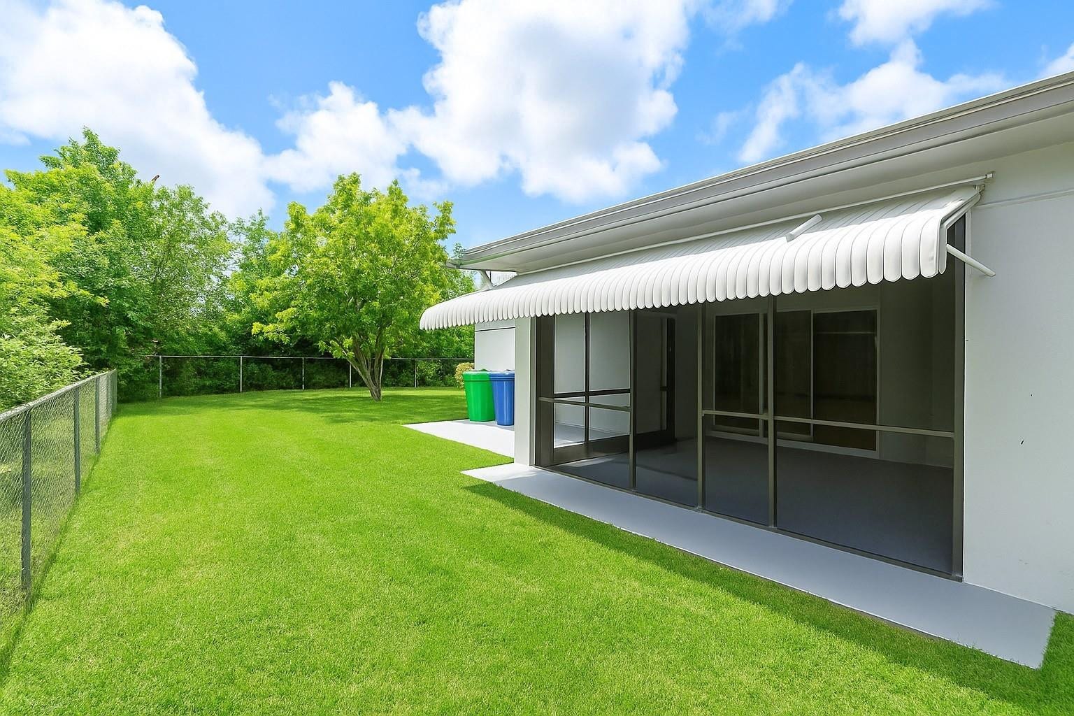 3843 NW 81st Terrace, Coral Springs, Coral Springs, FL 33065 Expansive green lawn with a chain-link fence and mature perimeter landscaping