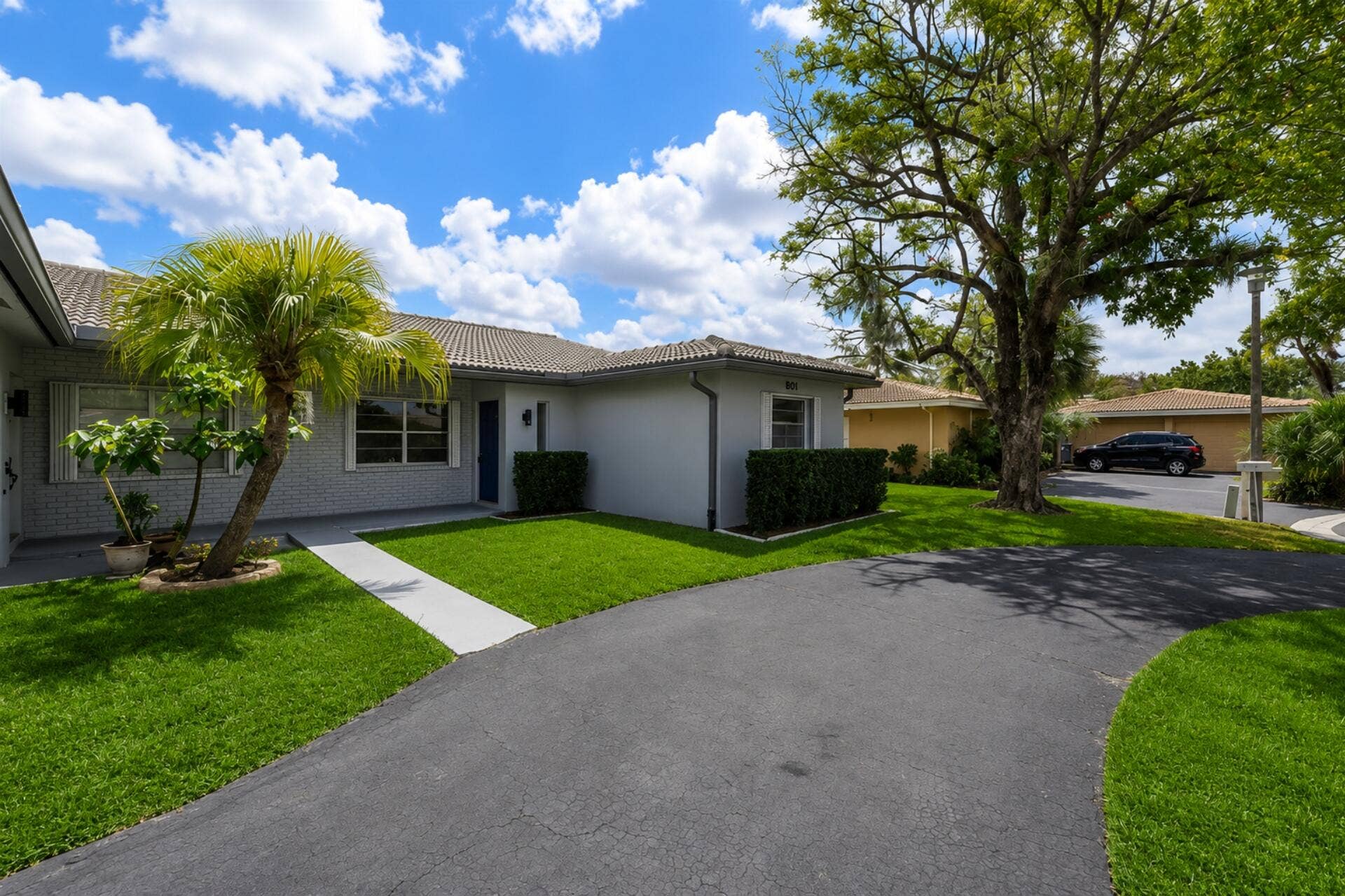 3843 NW 81st Terrace, Coral Springs, Coral Springs, FL 33065 Exterior facade featuring light gray brick and stucco, a dark blue entry door, and a concrete tile roof