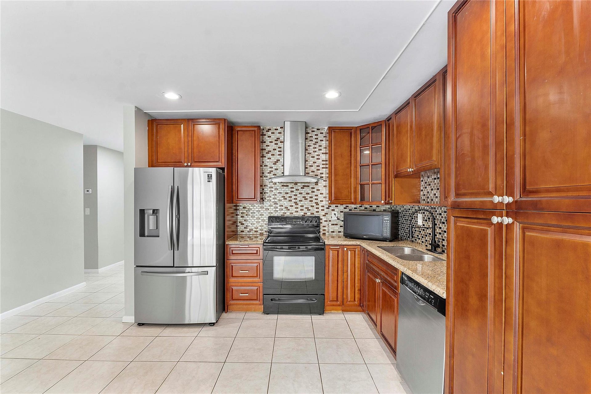 3843 NW 81st Terrace, Coral Springs, Coral Springs, FL 33065 Kitchen featuring wood-finish cabinetry, granite-style countertops, stainless steel appliances, a mosaic tile backsplash, and recessed lighting