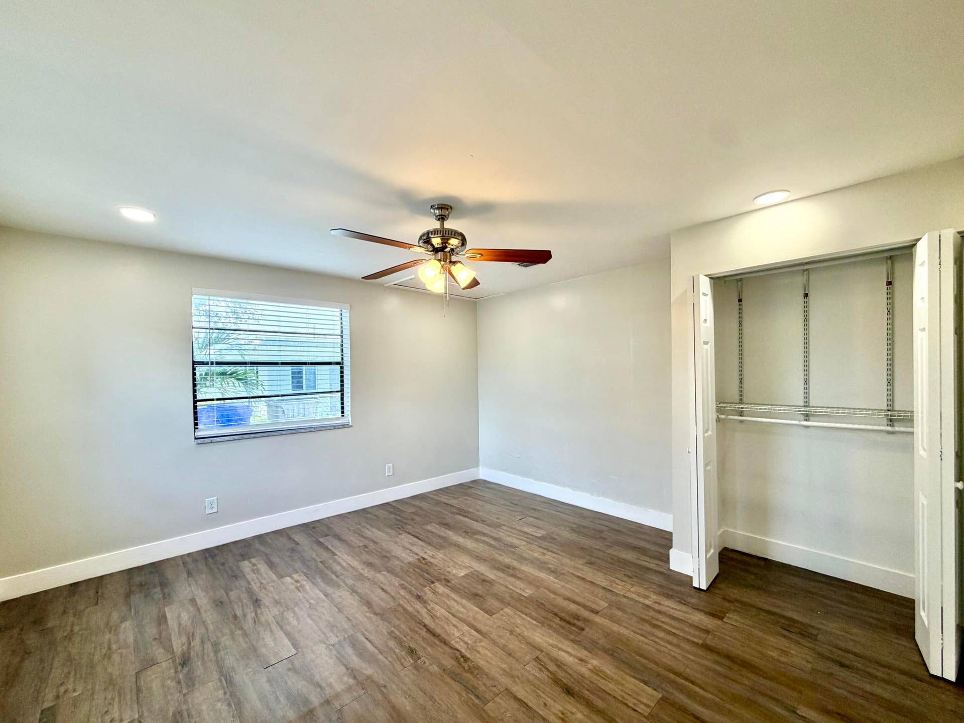 Bedroom 2 featuring wood-finish flooring, a window with blinds, a ceiling fan with integrated lighting, recessed lighting, and a bi-fold closet with shelving