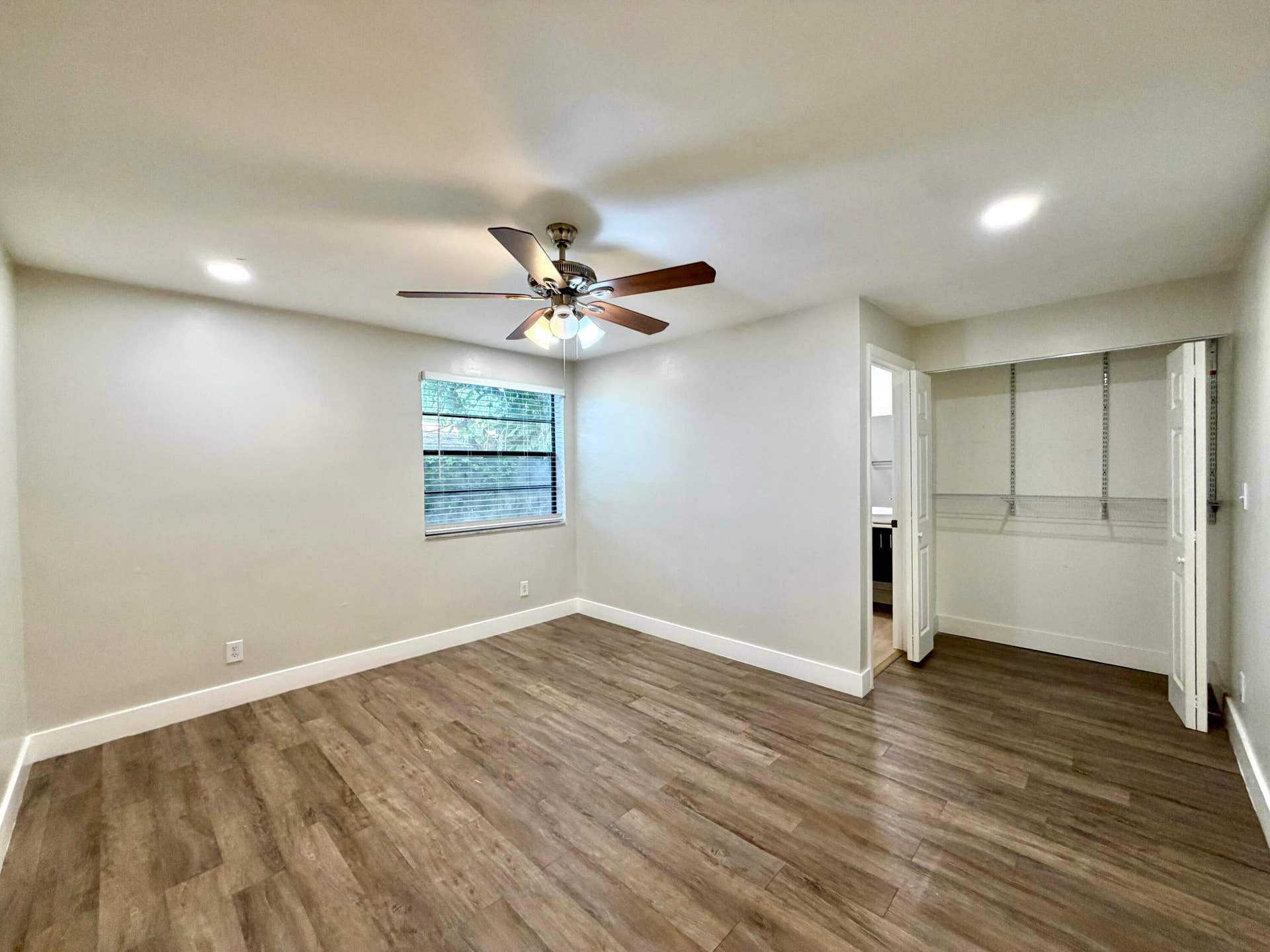 Room featuring wood-style laminate flooring, recessed lighting, and a ceiling fan with light fixture