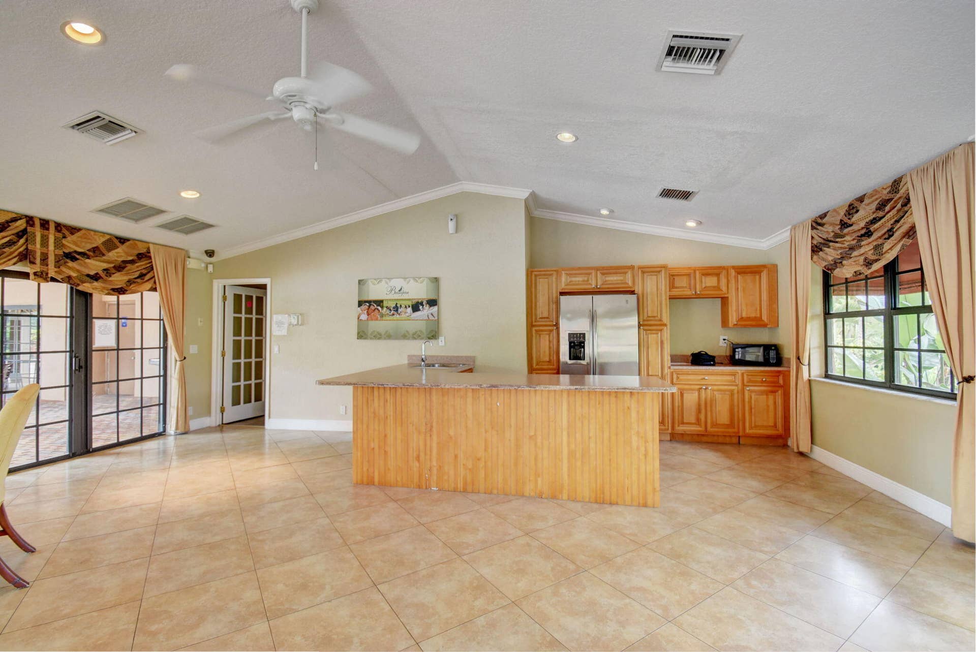 8230 Severn Drive, #A, Boca Raton, FL 33433 Kitchen featuring wood cabinetry, a stainless steel refrigerator, and a center island with a countertop