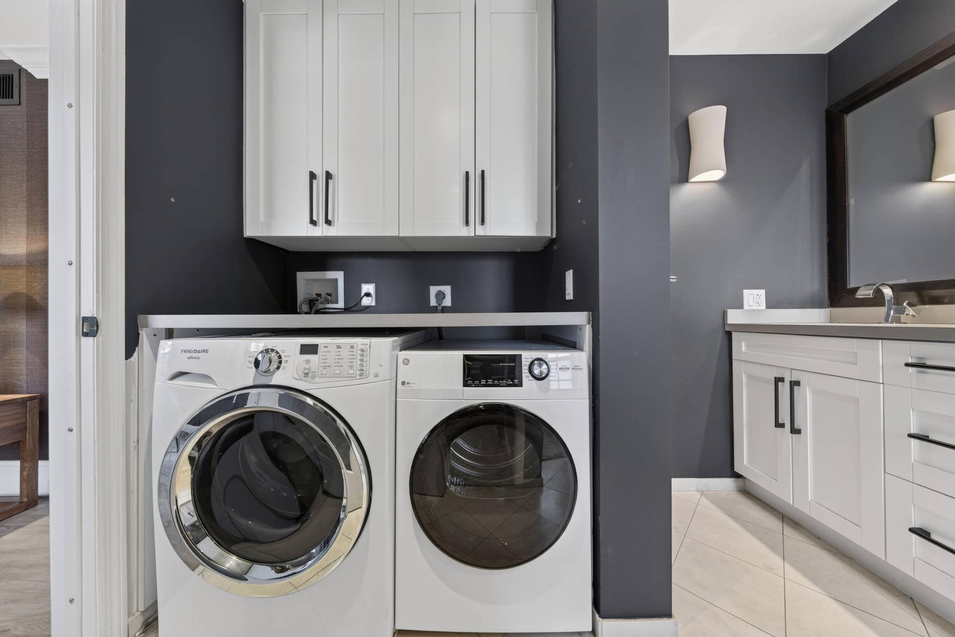 Dedicated laundry area featuring white shaker-style cabinetry, a built-in countertop,
