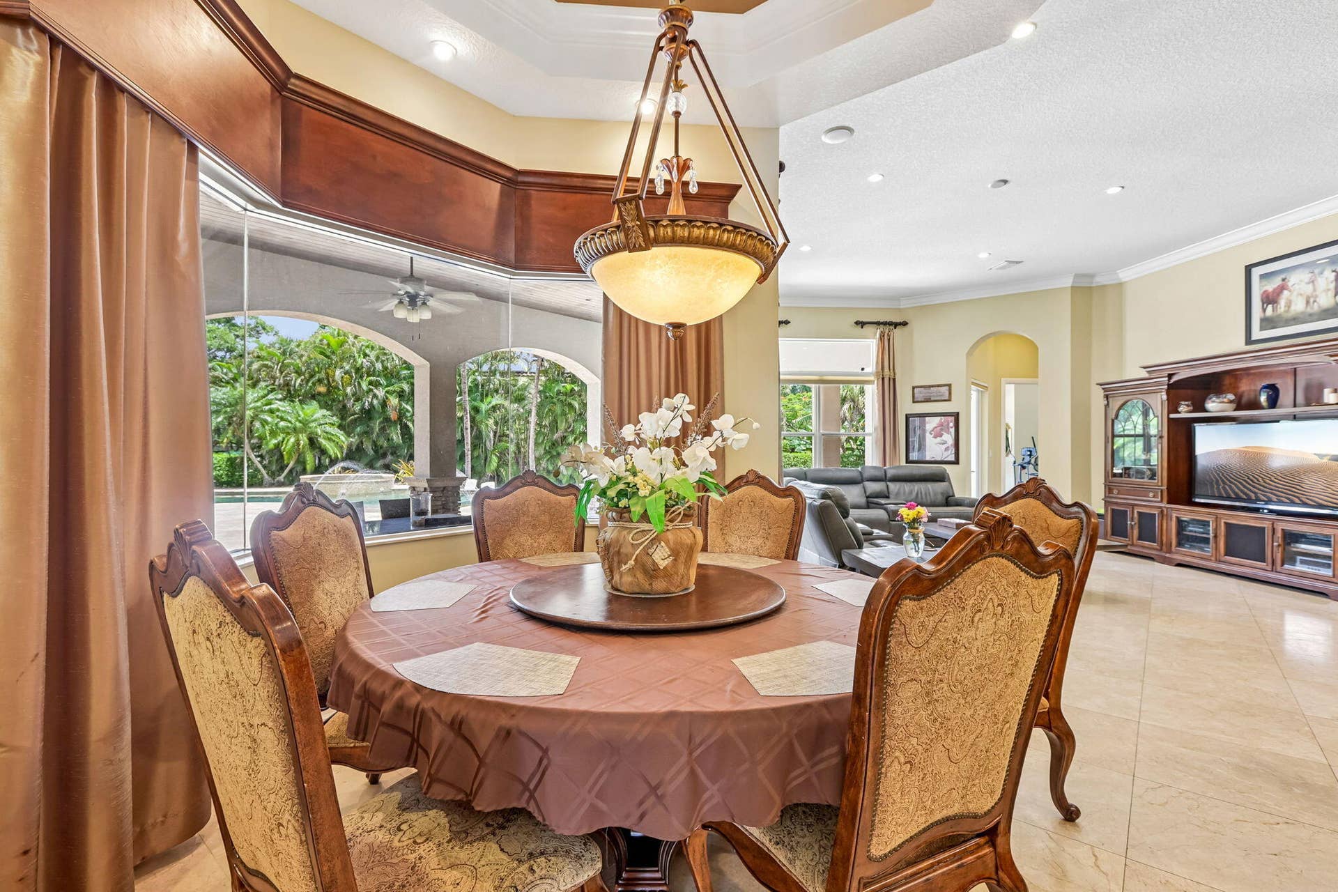 Dining area featuring a circular table, ornate chandelier, and large bay windows