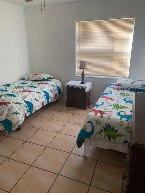 933 Francis Street, West Palm Beach, FL 33405 Room featuring light-toned tile flooring, neutral wall paint, and a window with horizontal blinds