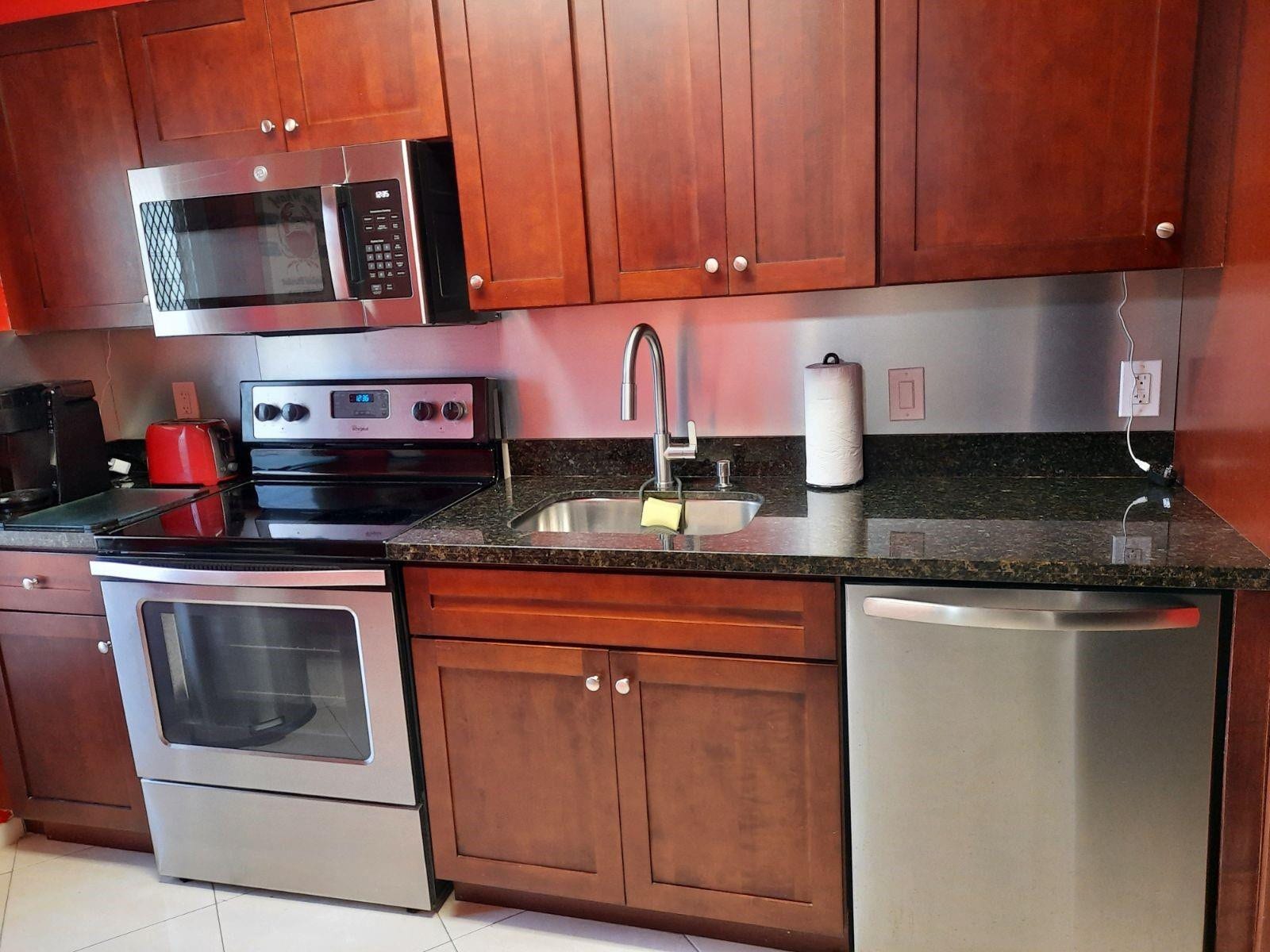 4500 N Federal Highway, #253F, Lighthouse Point, Lighthouse Point, FL 33064 Kitchen featuring wood-finish cabinetry, dark granite-style countertops, stainless steel appliances, stainless steel backsplash, and an undermount sink with a gooseneck faucet