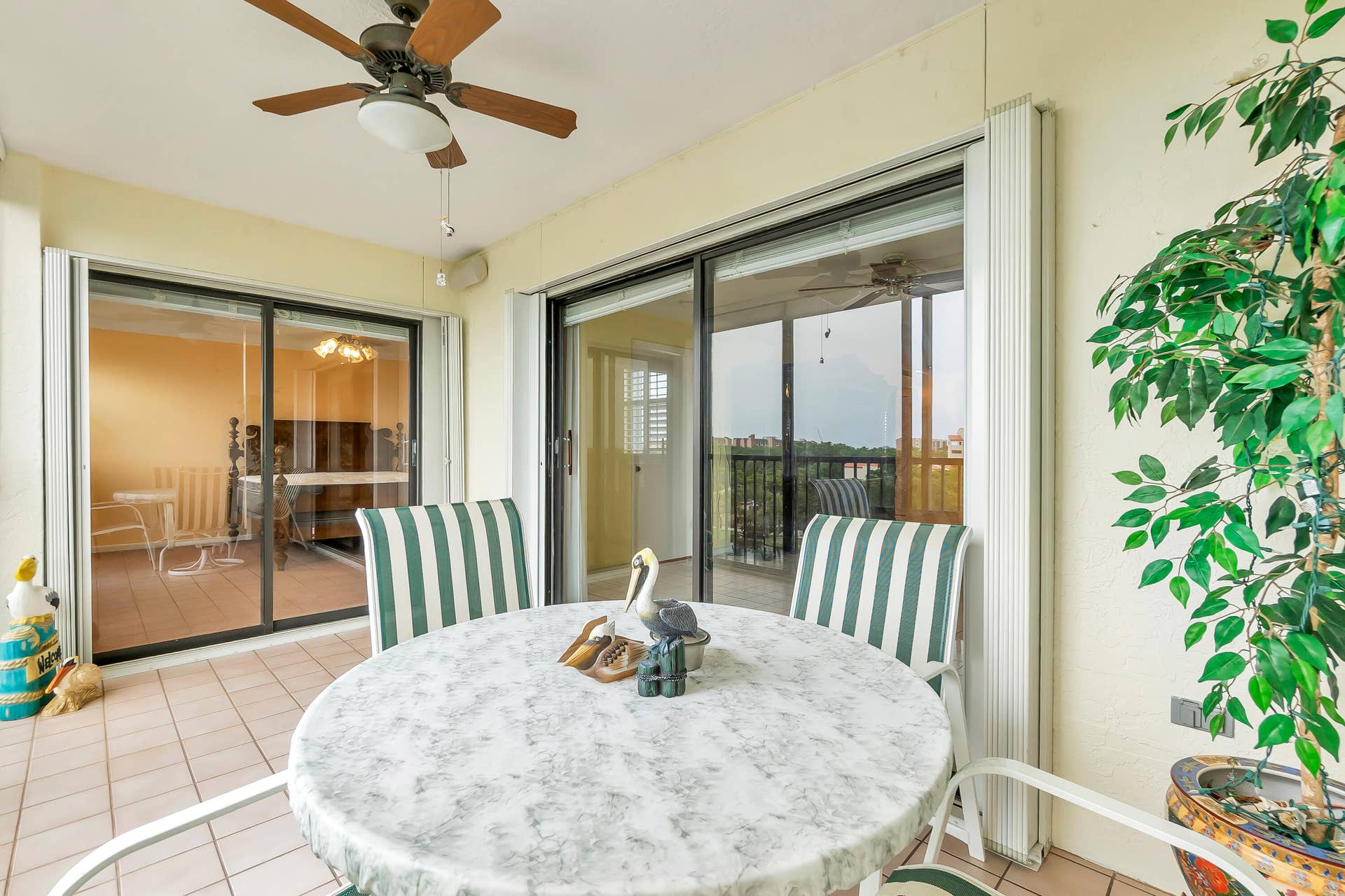 2334 S Cypress Bend Drive, #602, Pompano Beach, FL 33069 Tiled outdoor patio with a ceiling fan and full accordion hurricane shutters