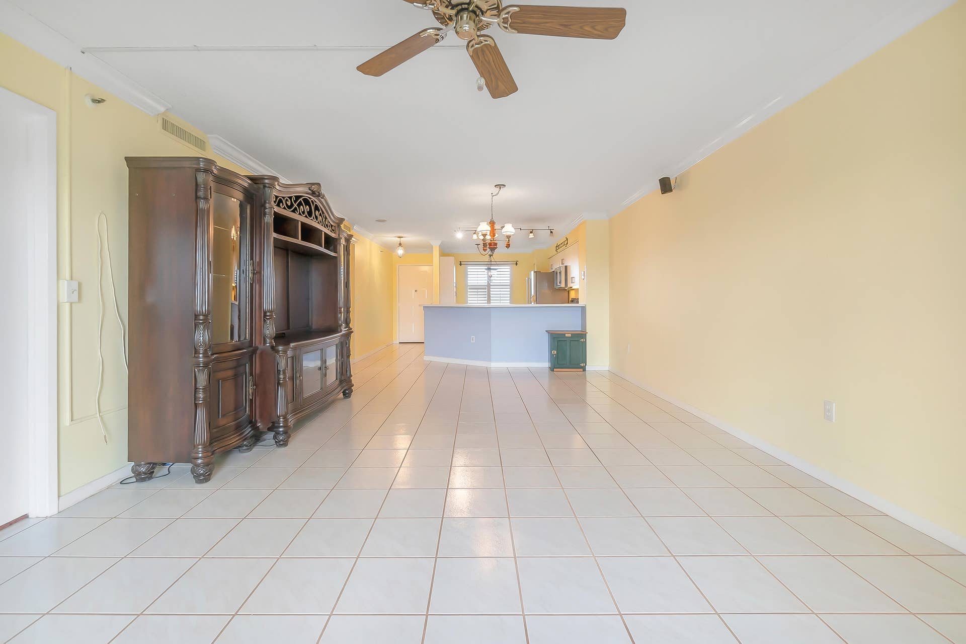 2334 S Cypress Bend Drive, #602, Pompano Beach, FL 33069 Expansive living-dining room featuring white tile flooring, crown molding, and a ceiling fan