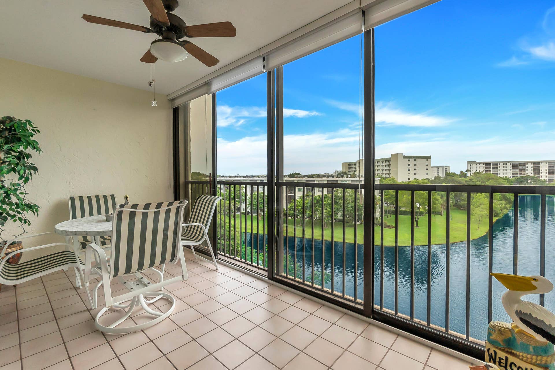 2334 S Cypress Bend Drive, #602, Pompano Beach, FL 33069 Expansive enclosed/screened balcony featuring a tiled floor, a ceiling fan and sliding door option