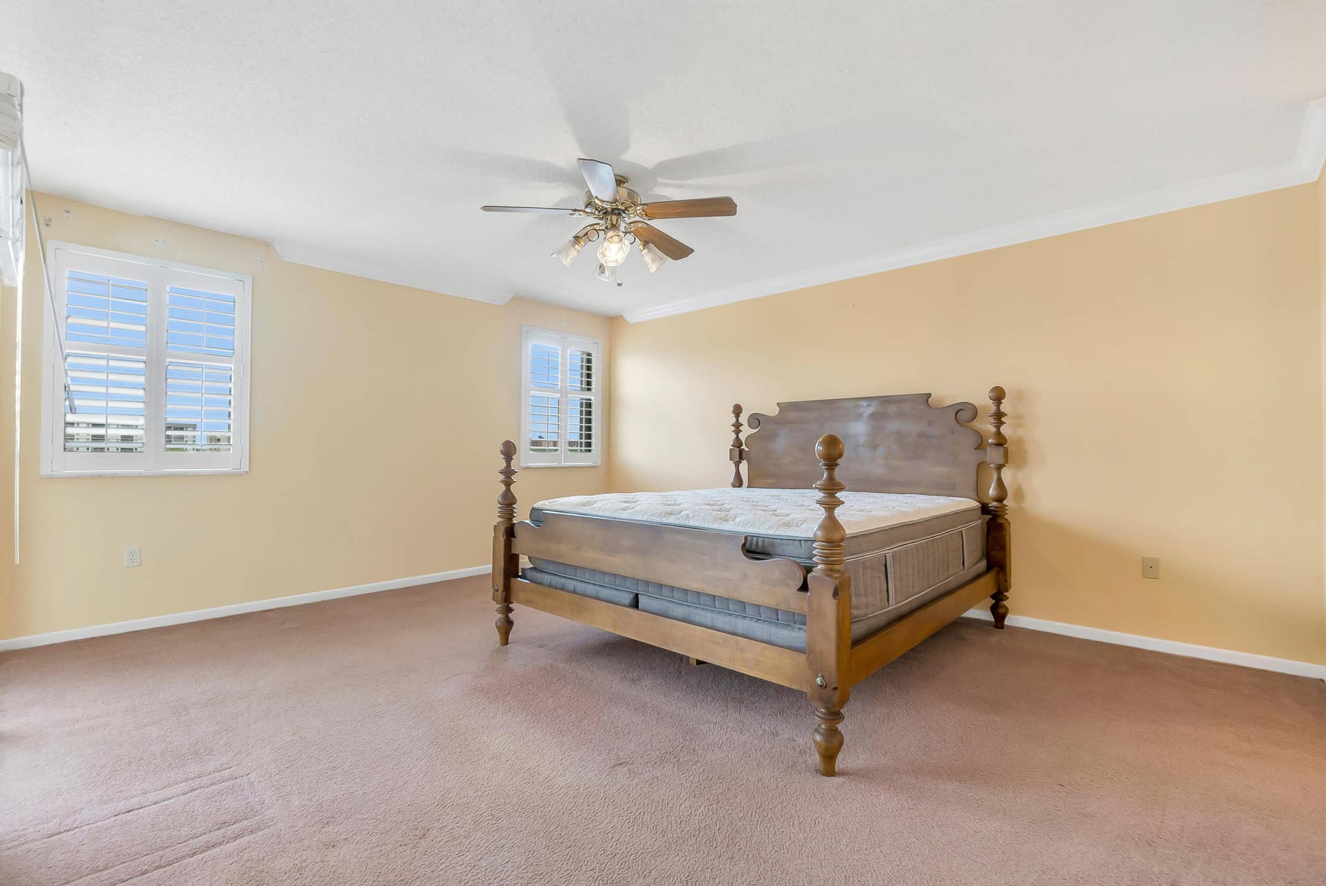 2334 S Cypress Bend Drive, #602, Pompano Beach, FL 33069 Spacious primary bedroom featuring carpeting, a ceiling fan with integrated lighting, and crown molding