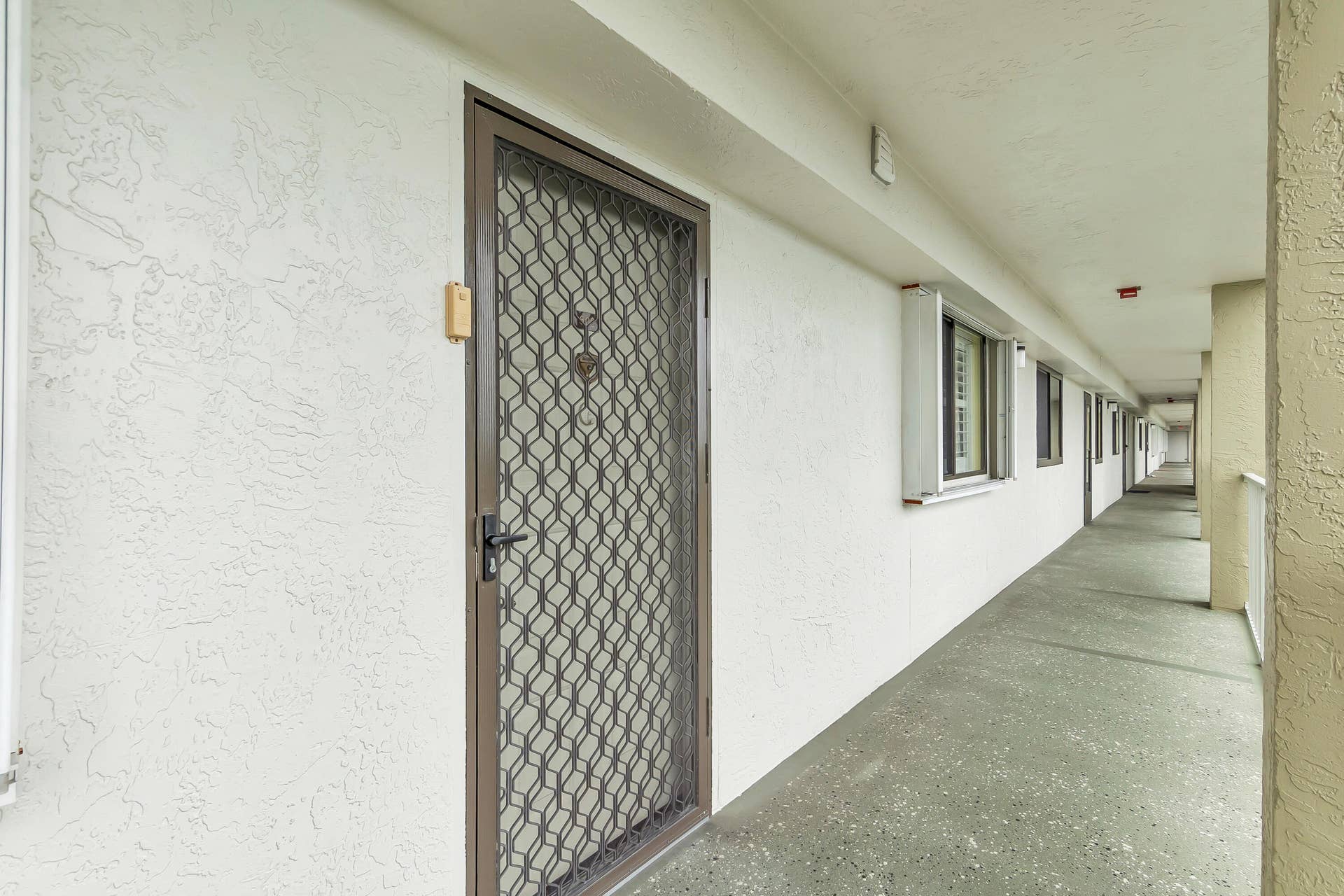 2334 S Cypress Bend Drive, #602, Pompano Beach, FL 33069 Brown metal screened security door with an abstract geometric pattern