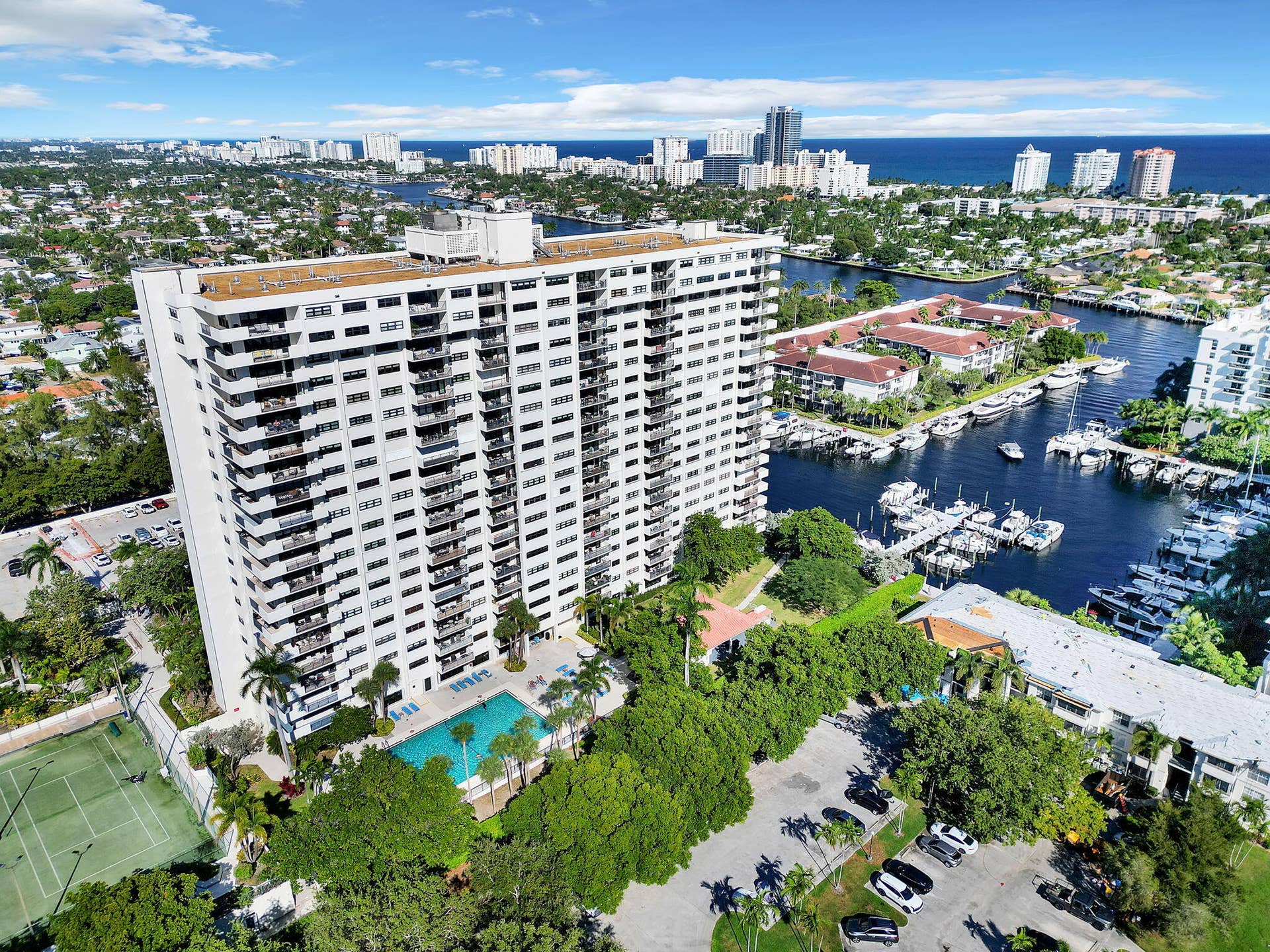 3200 Port Royale Drive N, #902, Fort Lauderdale, FL 33308 Multi-story high-rise residential building featuring private balconies, an outdoor swimming pool, and a tennis court