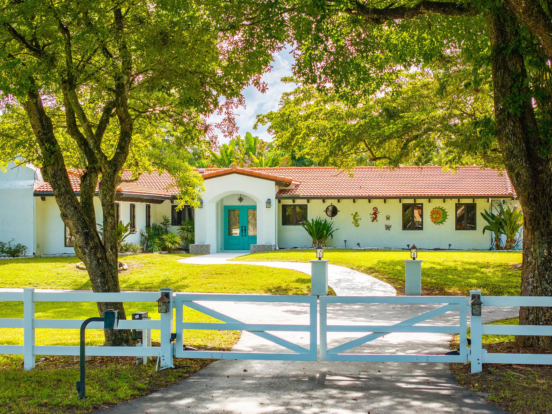 4950 Thoroughbred Lane, Southwest Ranches, FL 33330 Beautifully updated residence featuring a newer terracotta tile roof, white stucco exterior, and a inviting entryway